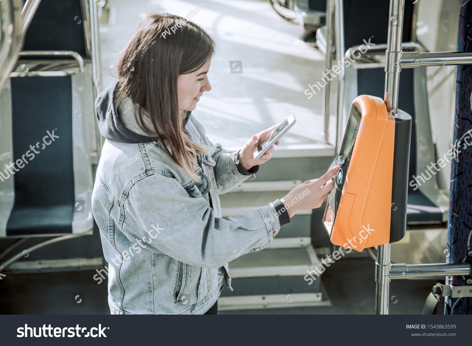 A young woman contactless pays for public transport. Payment by card  Bank transfer .