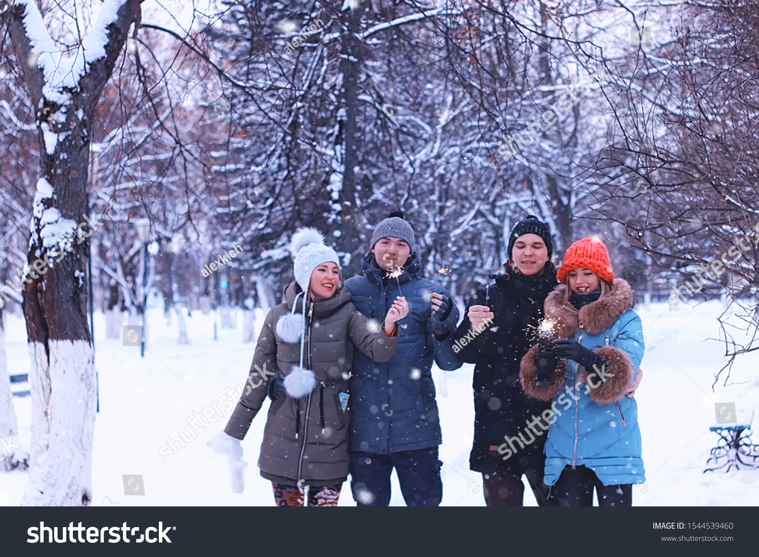 group of young people with sparklers winter