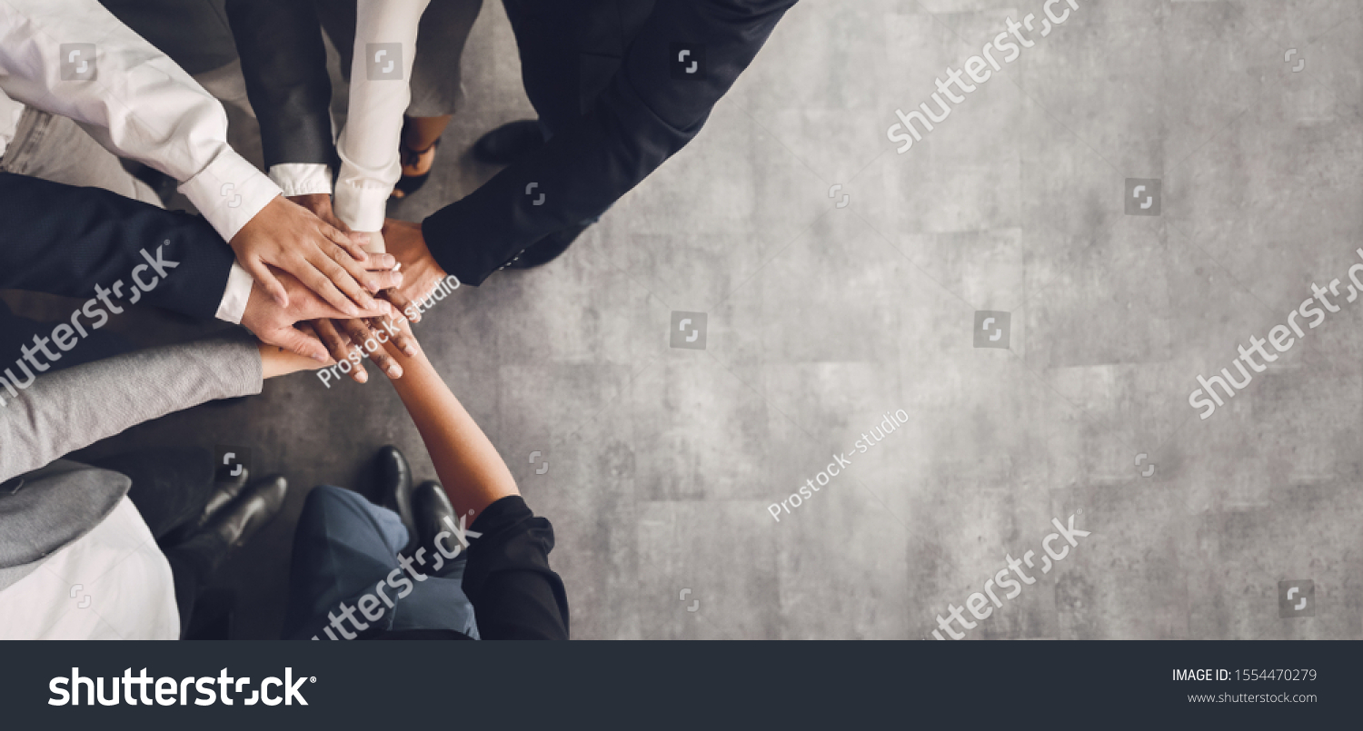 Teambuilding concept. Business team putting their hands together  top view  free space  panorama