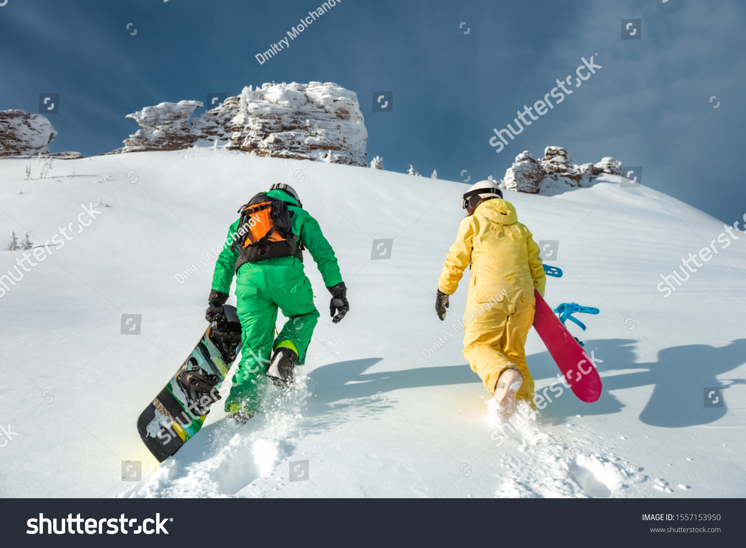 Two snowboarders walking uphill. Backcountry skiing and snowboarding concept at ski resort