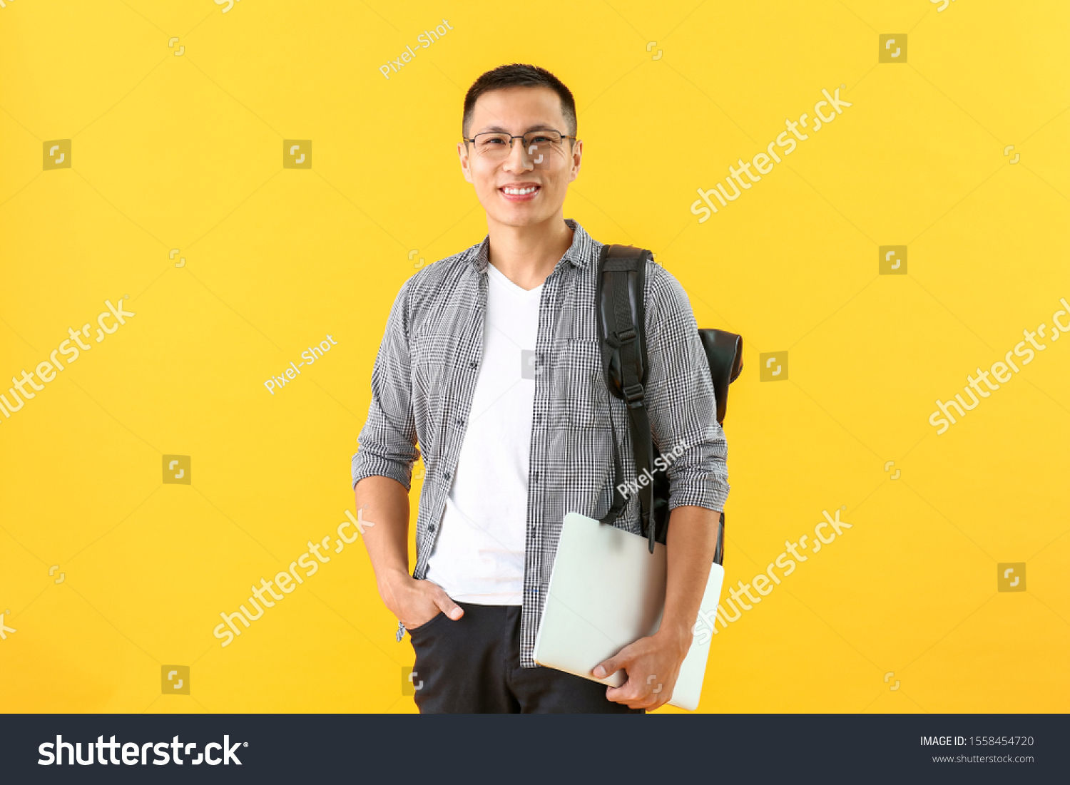 Male Asian student with laptop on color background