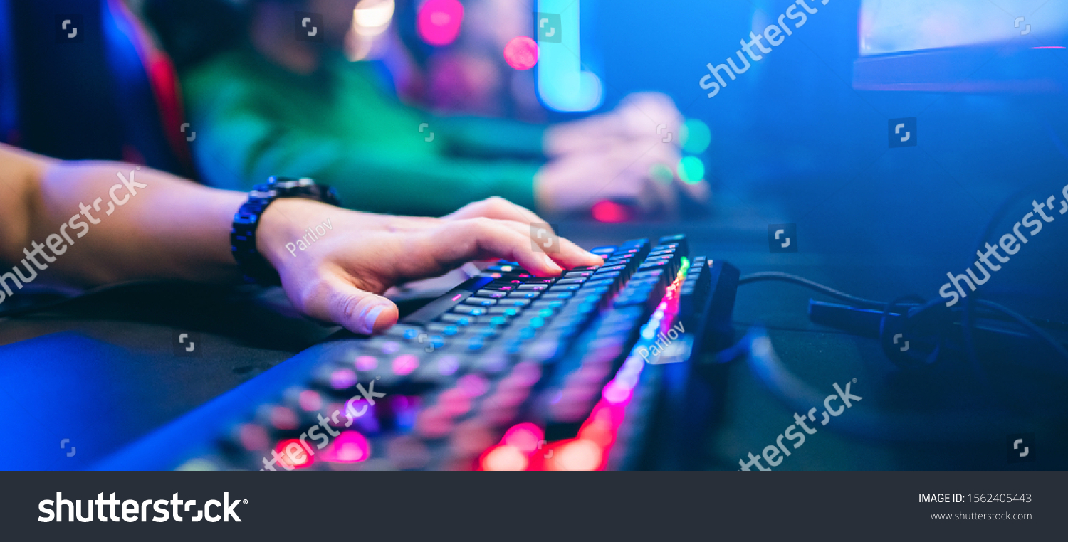 Professional cyber video gamer studio room with personal computer armchair  keyboard for stream in neon color blur background. Soft focus.