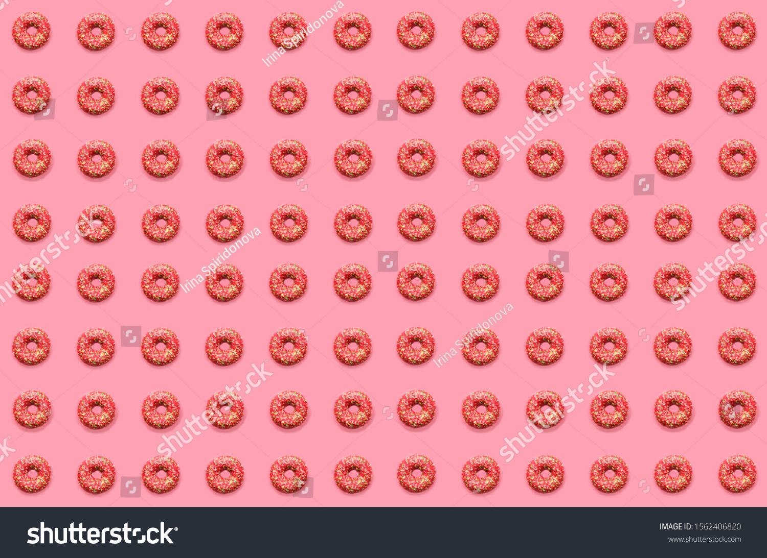 Doughnut pattern. Thel pattern of pink doughnuts lay flat on a pink background.