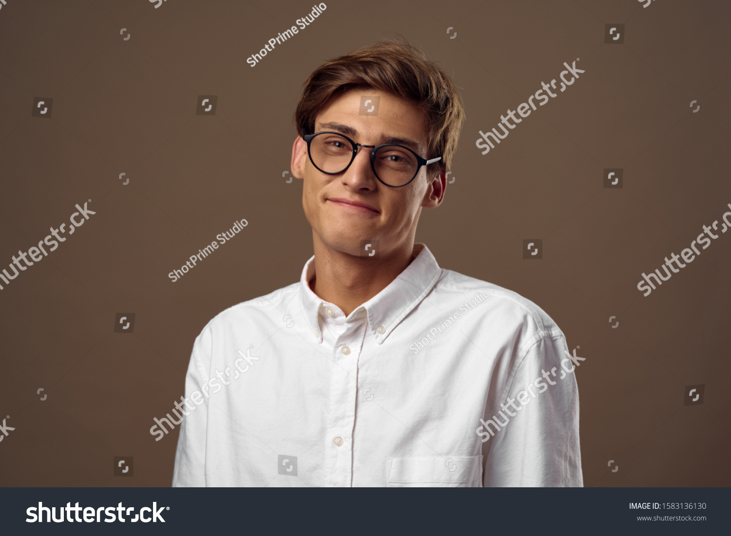 Handsome man with glasses on a brown background white shirt
