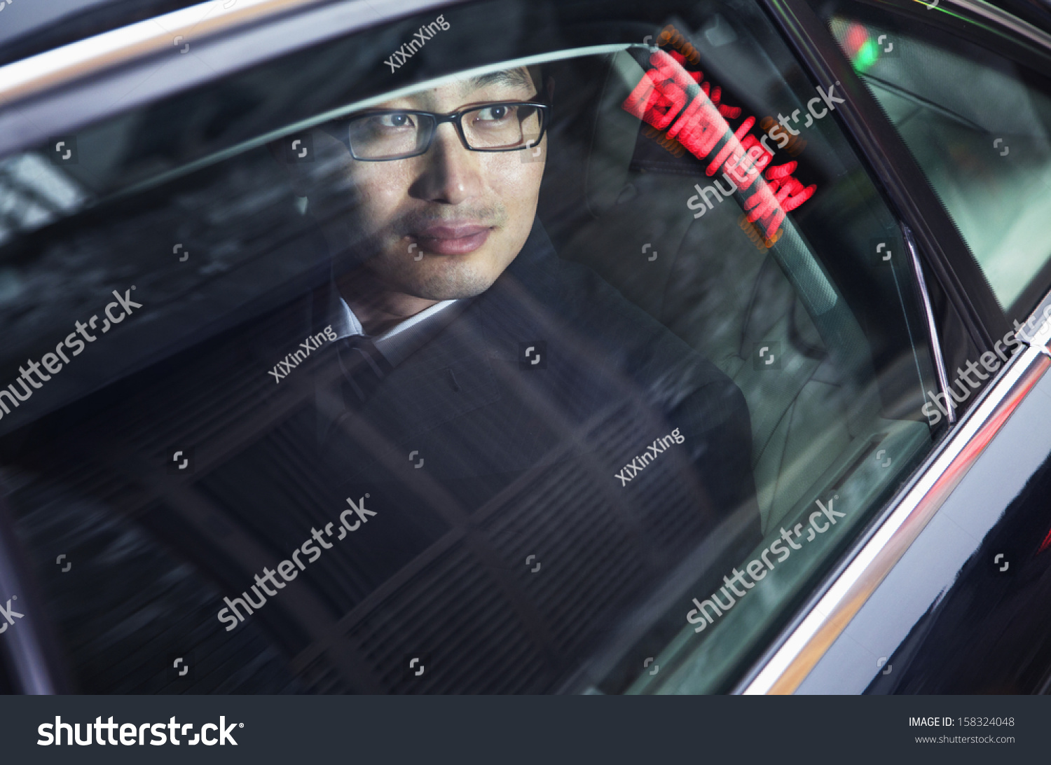 Contemplative businessman looking through car window at the night