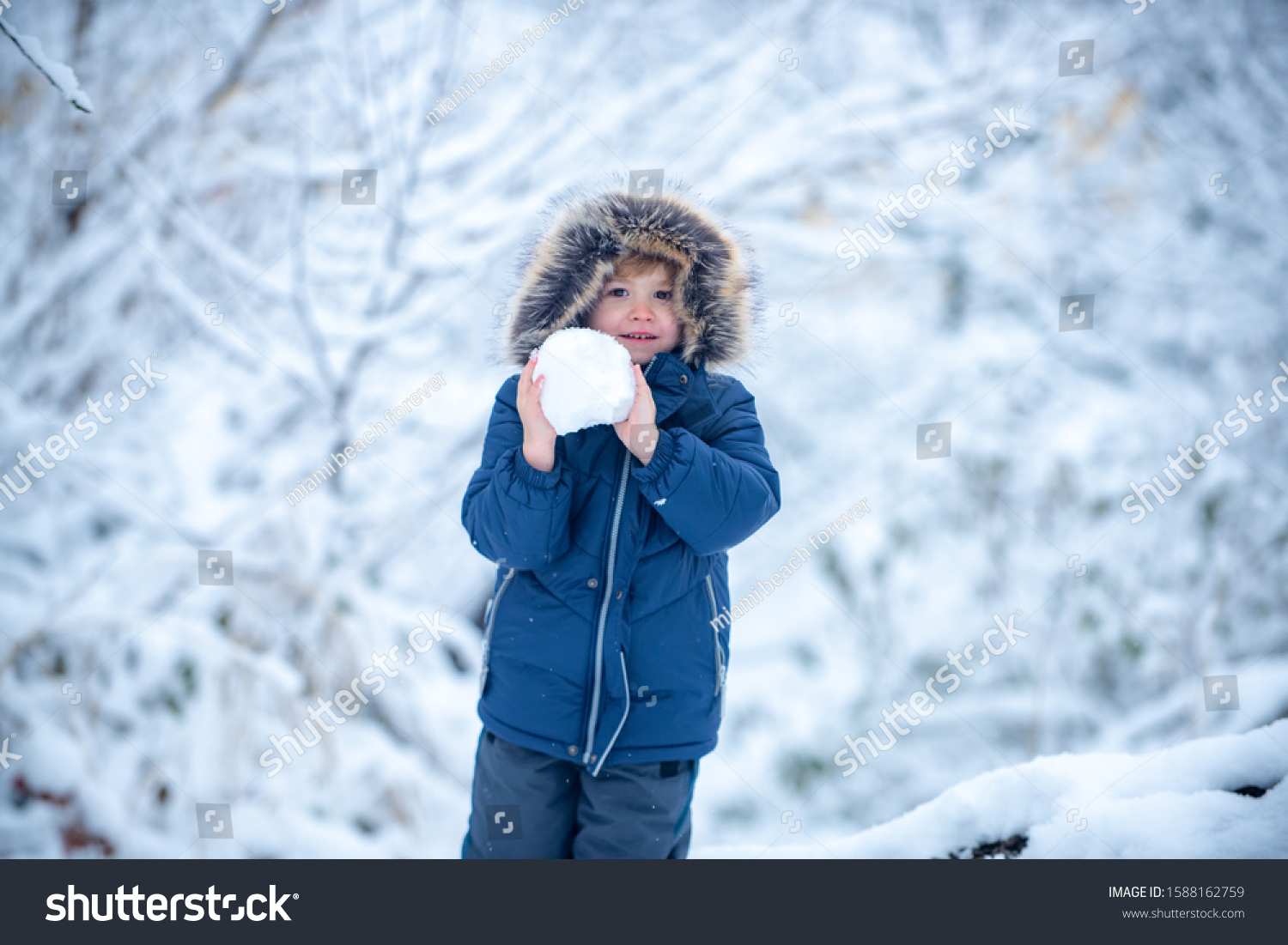 Winter at countryside. Little child boy walking in winter field. Well dressed enjoying the winter. Kids winter portrait