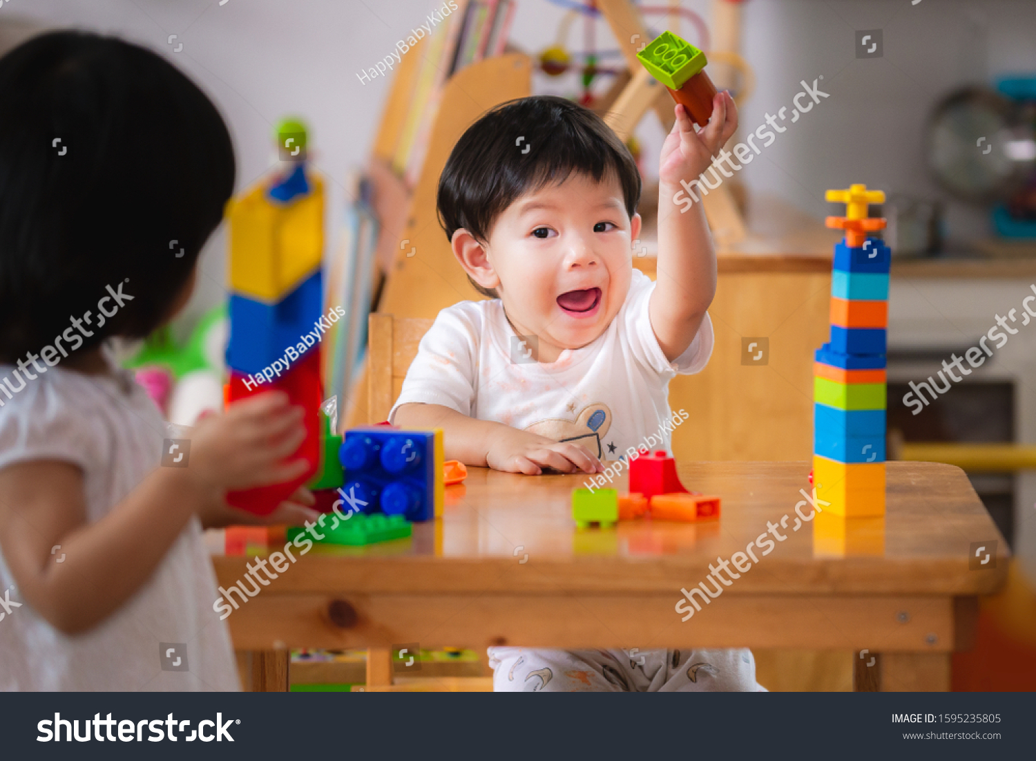 Baby age 1 years and 2 years old. Asian boy and girl playing with colorful plastic blocks.Children are learning to design and build from toys. Hand muscle development.