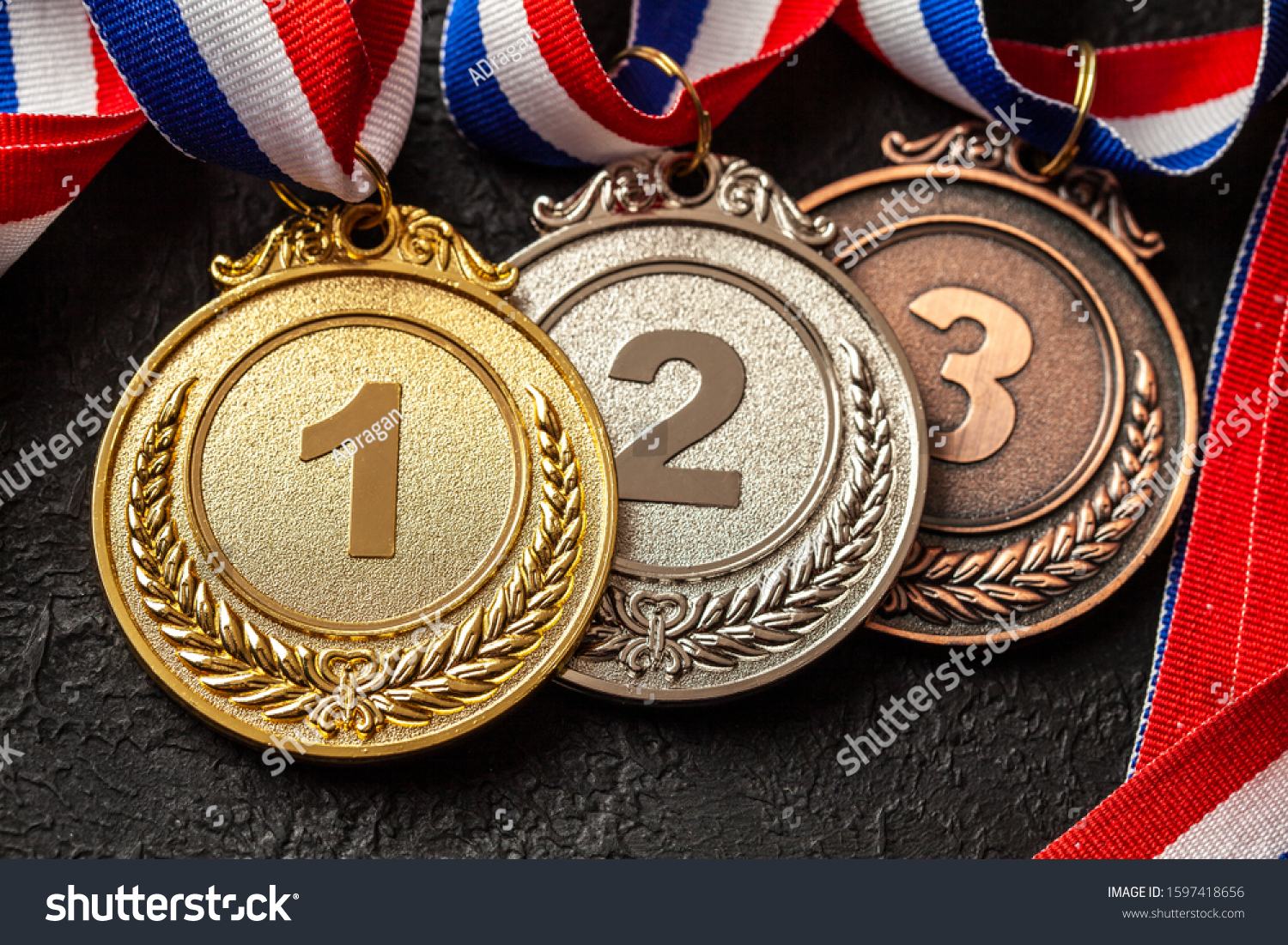 Gold  silver and bronze medal with ribbons. Award for first  second and third place in the competition. Prize to the champion. Black background.