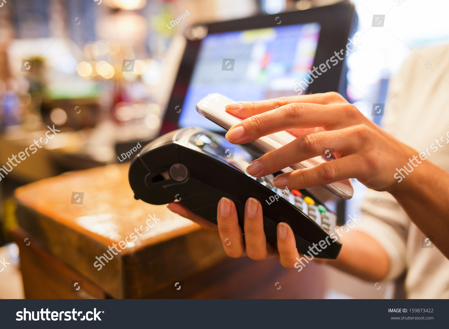 Woman paying with NFC technology on mobile phone  restaurant  cafe  bar