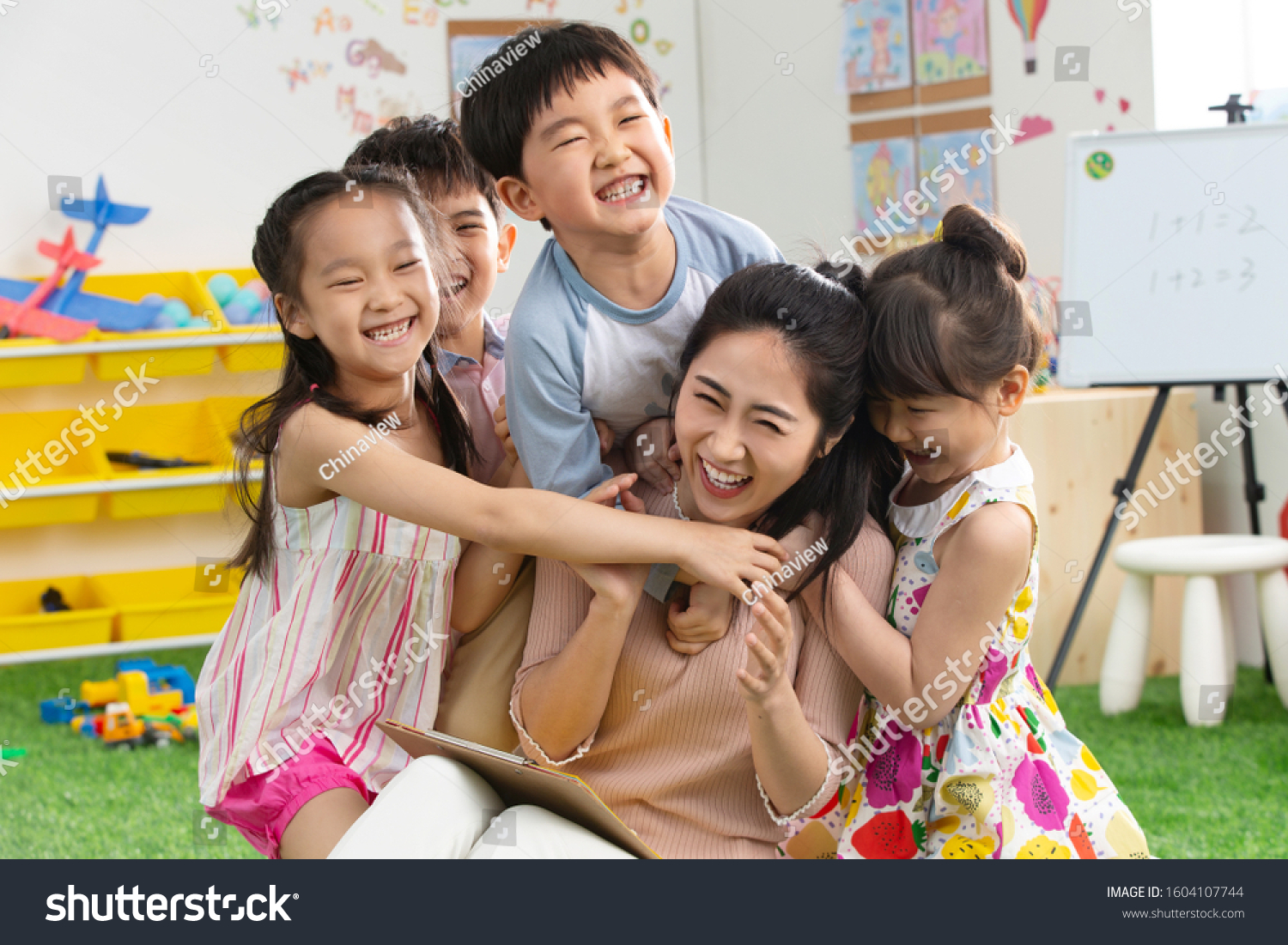 Kindergarten teachers and children embrace together