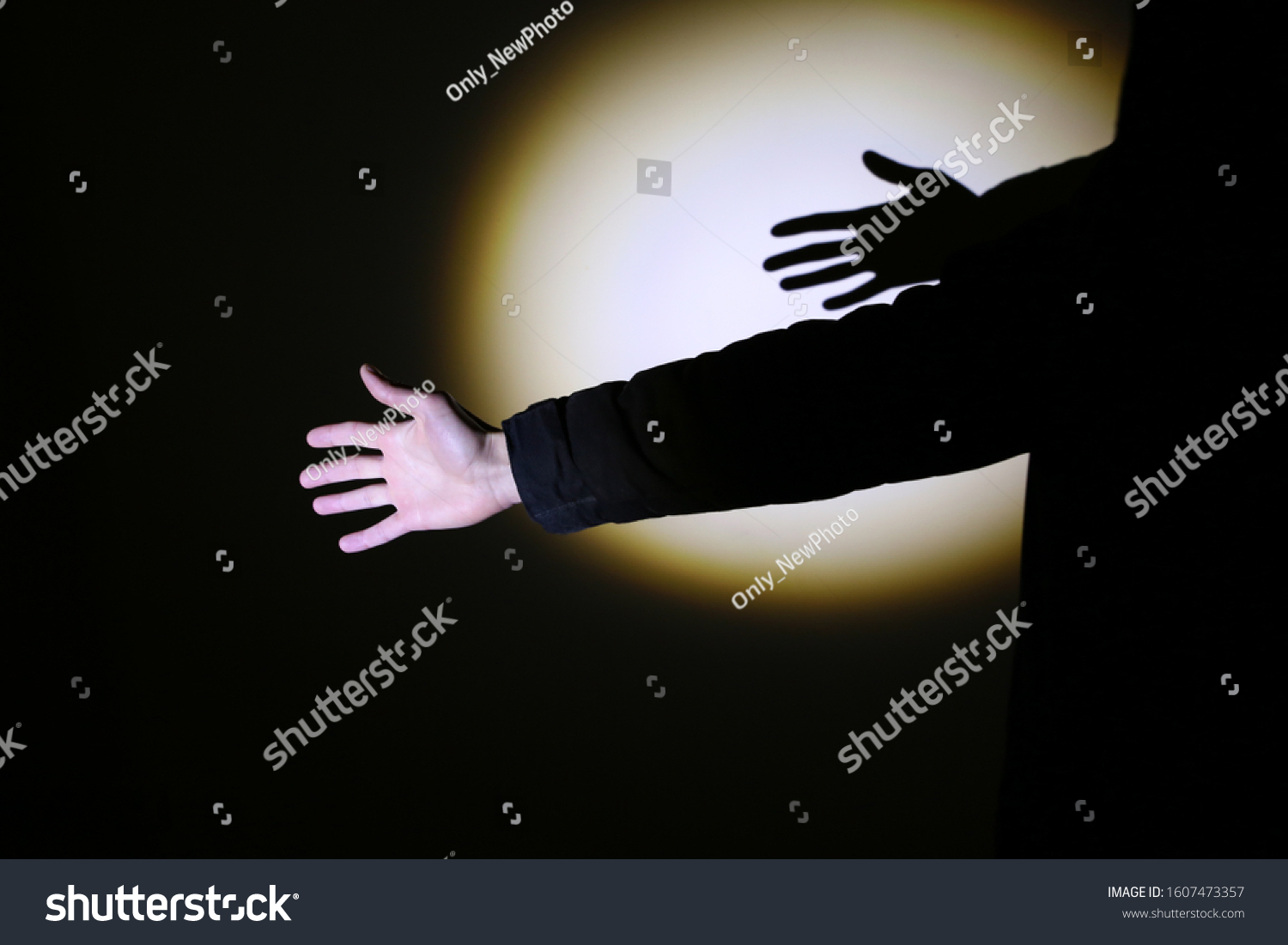 Man's hand in spotlight on black background.