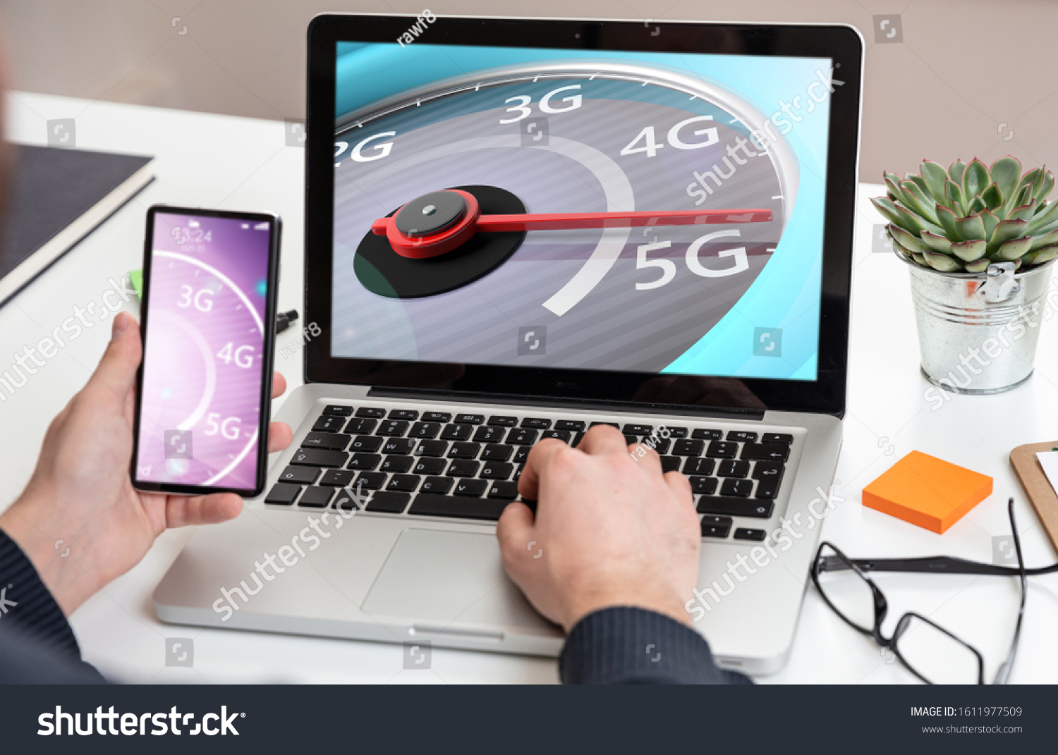5G internet speed test high speed concept. Man holding a mobile phone speedometer 5G speed network connection on the computer laptop screen business office background.