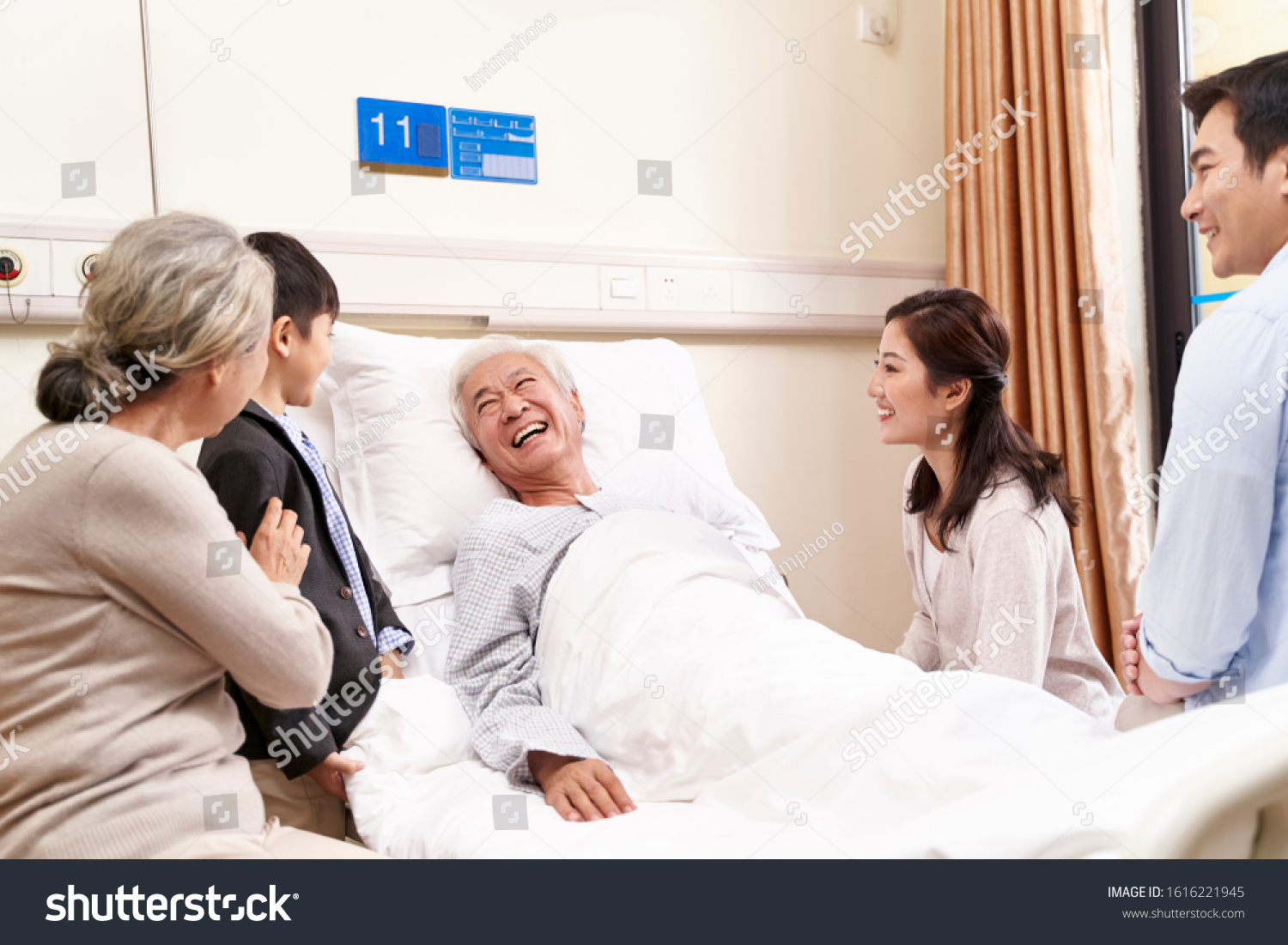 asian family with child visiting grandparents in hospital