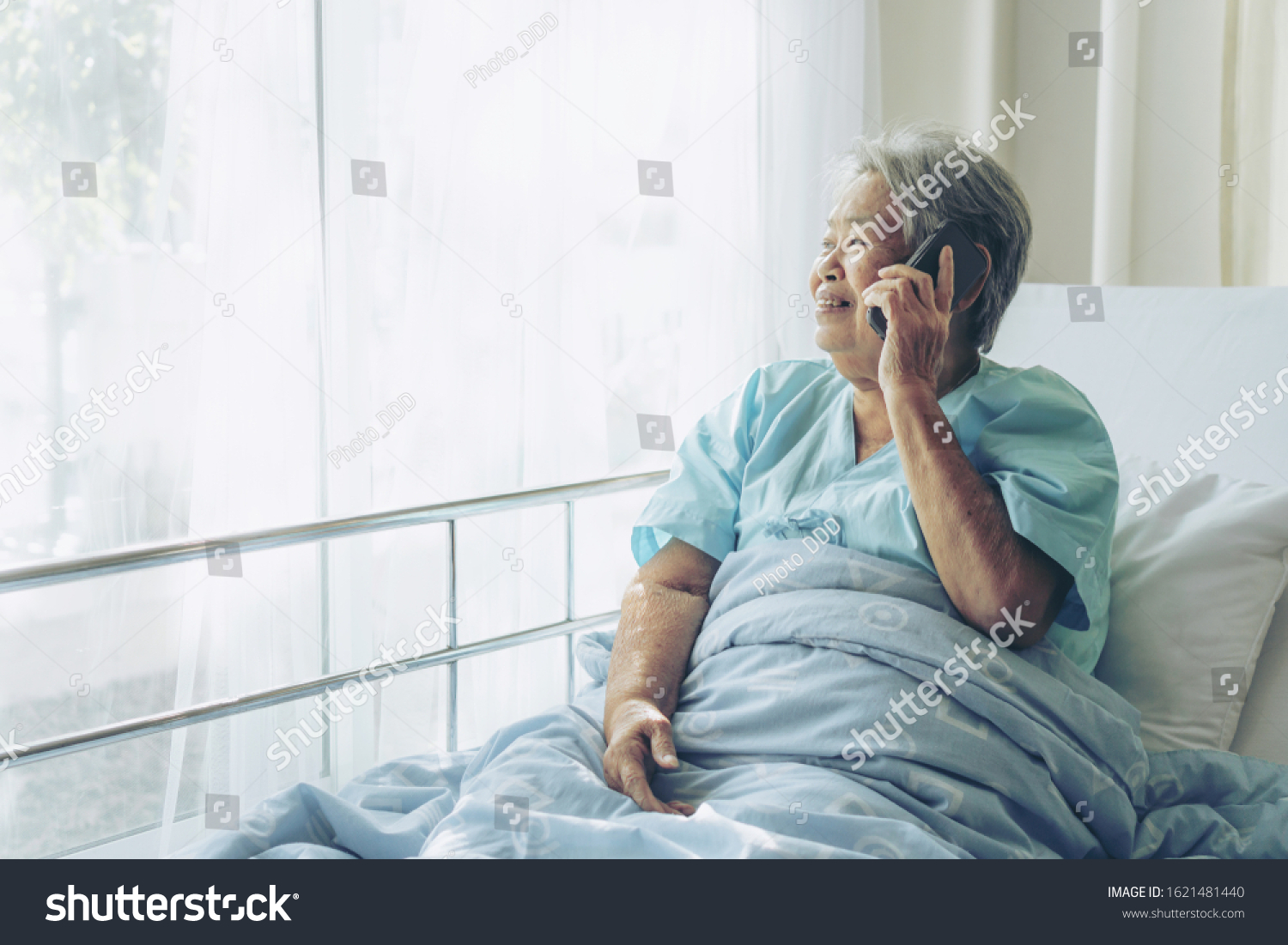 Elderly patients in hospital bed patients using smart phone call to descendant relatives feel happiness - medical and healthcare concept