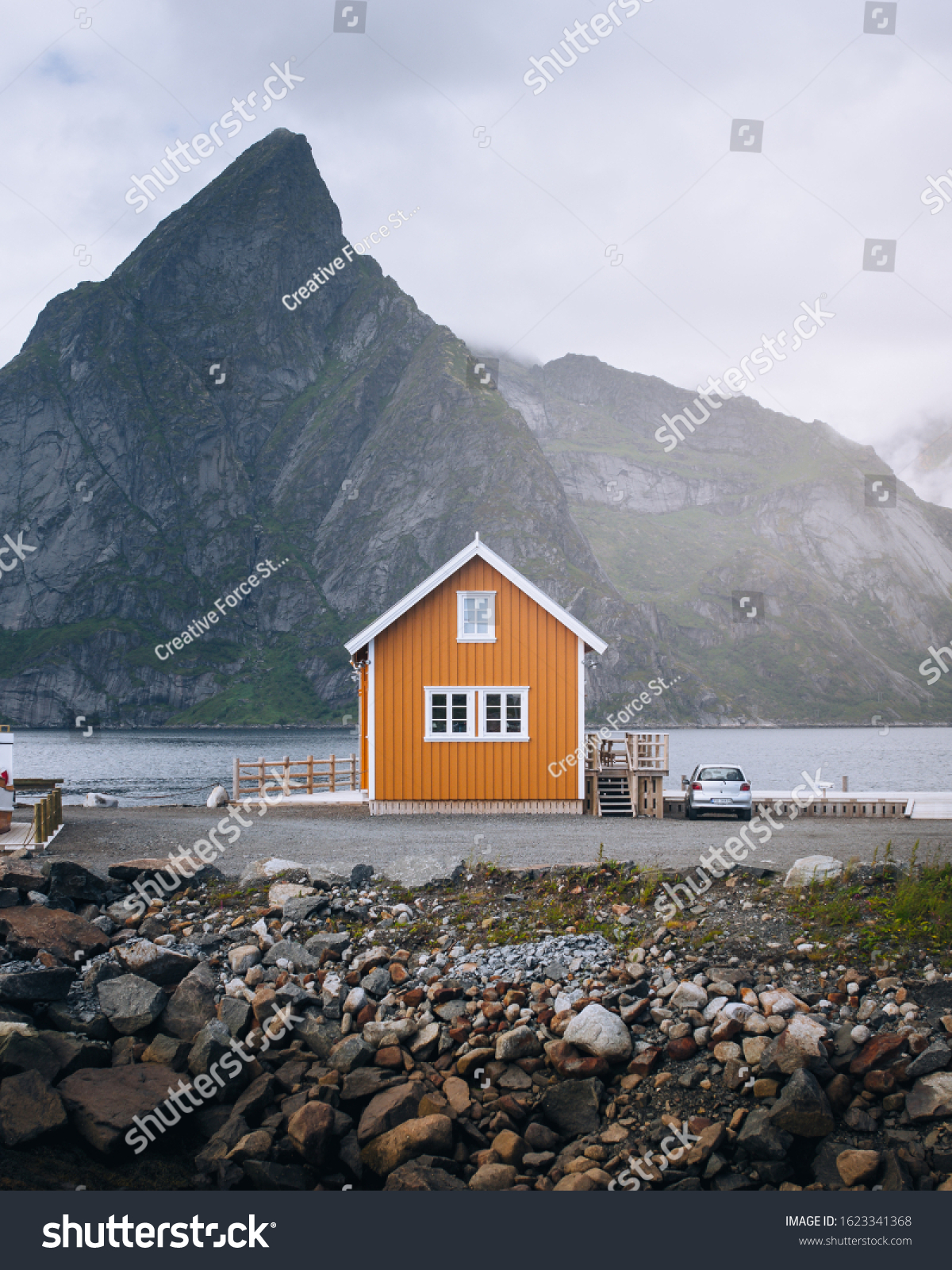 Wooden fisherman cabin on Lofoten Islands Norway. Norwegian coast landscape with a typical yellow house.
