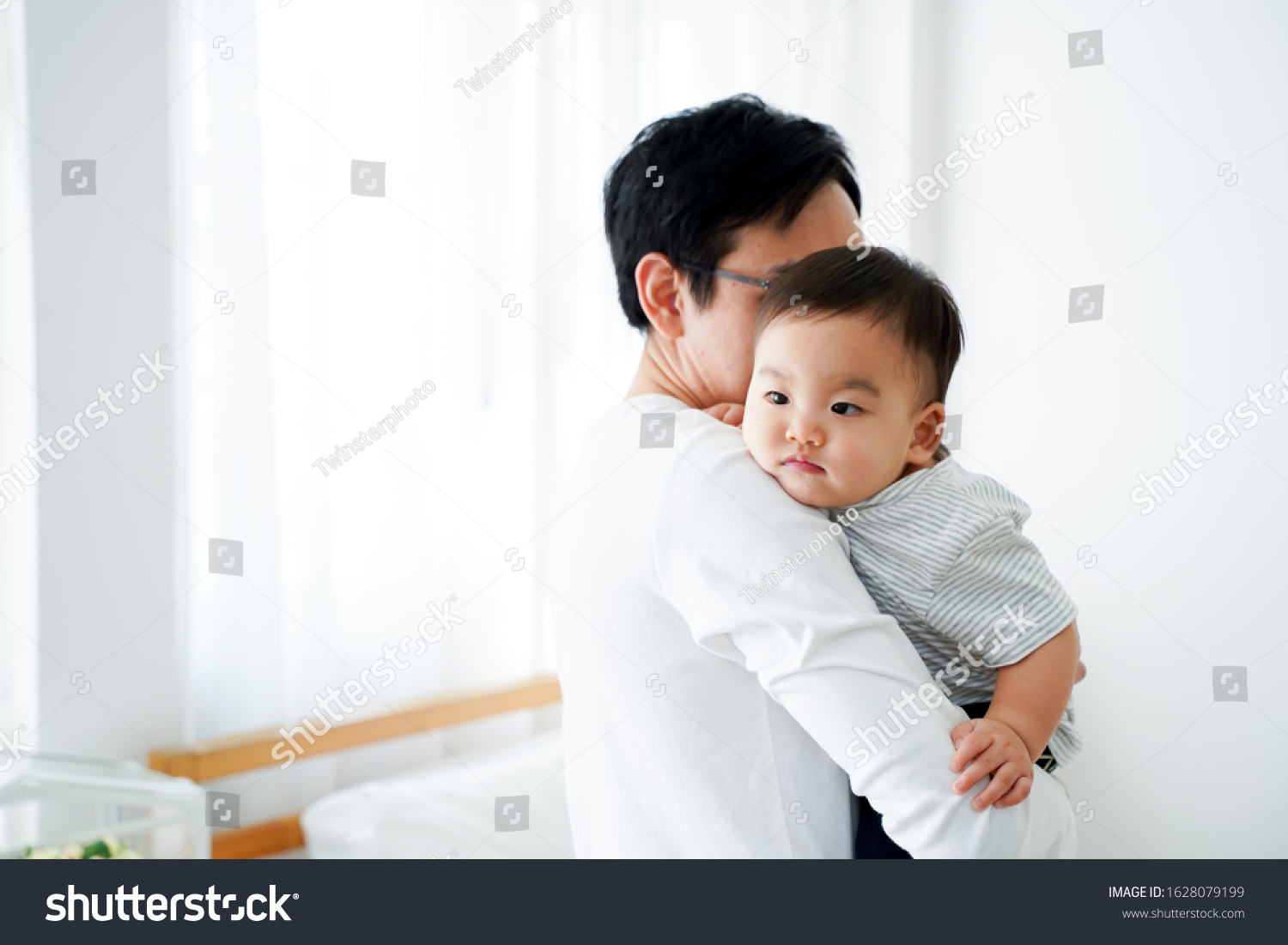 Happy Asian father and baby boy toddler at home  enjoying family time together