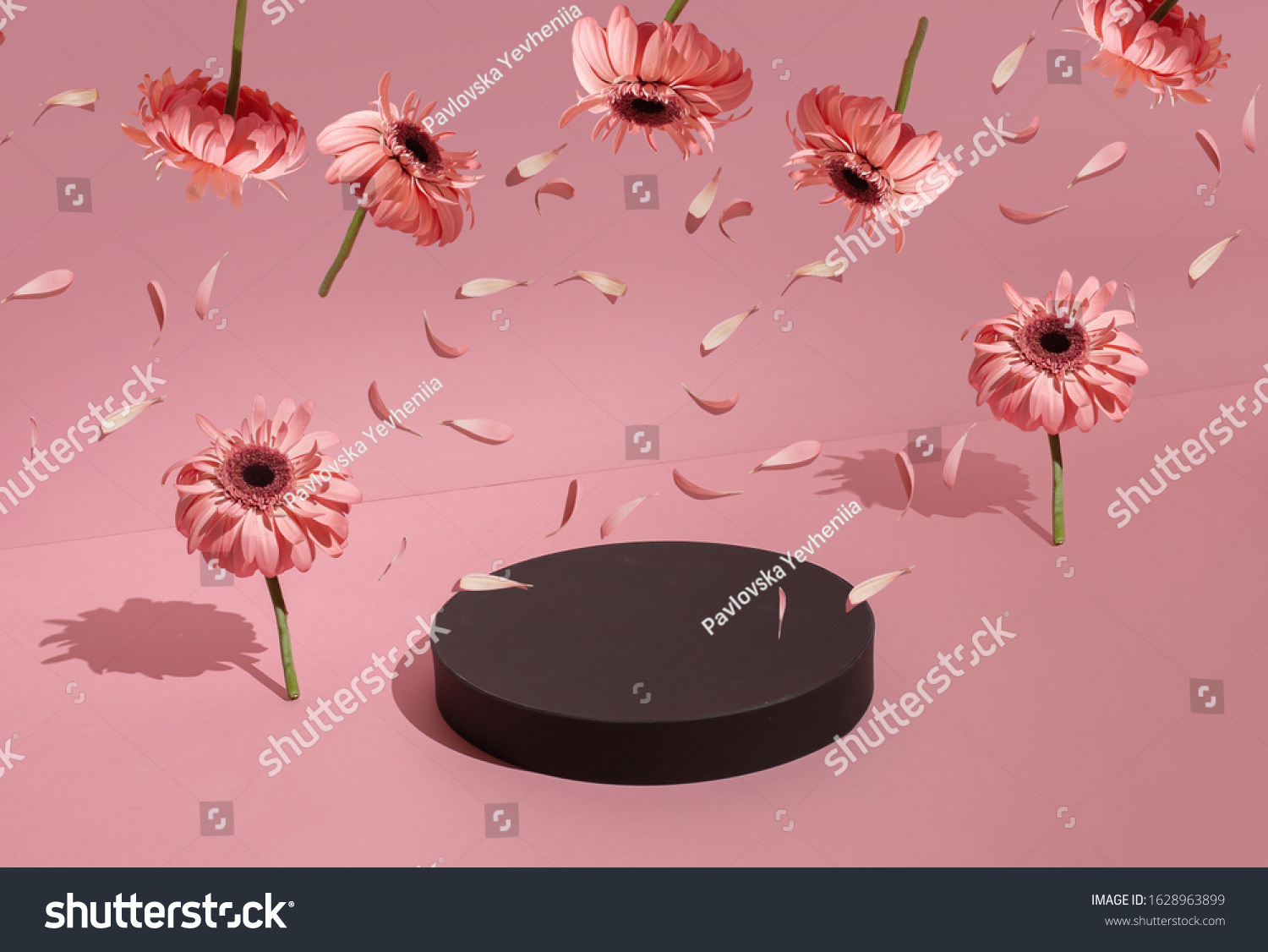 Podium for the product around the flowers on a pastel pink background.