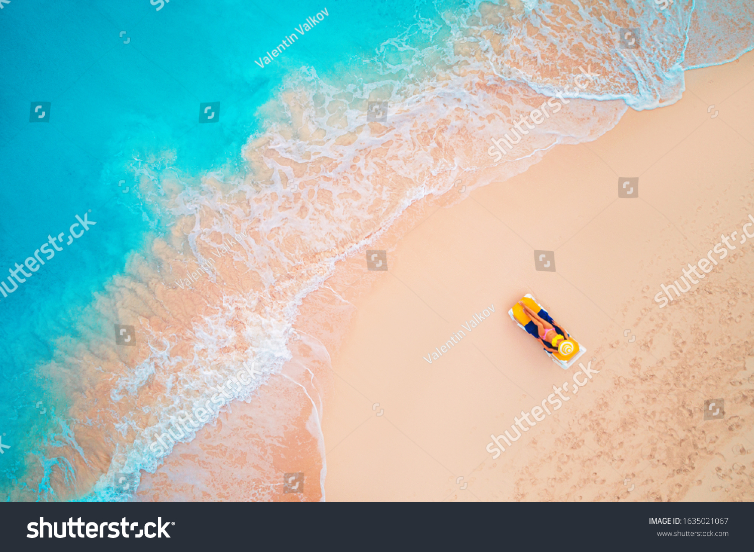 Aerial view of a woman on the beach in a bikini lying and sunbathing._站 ...