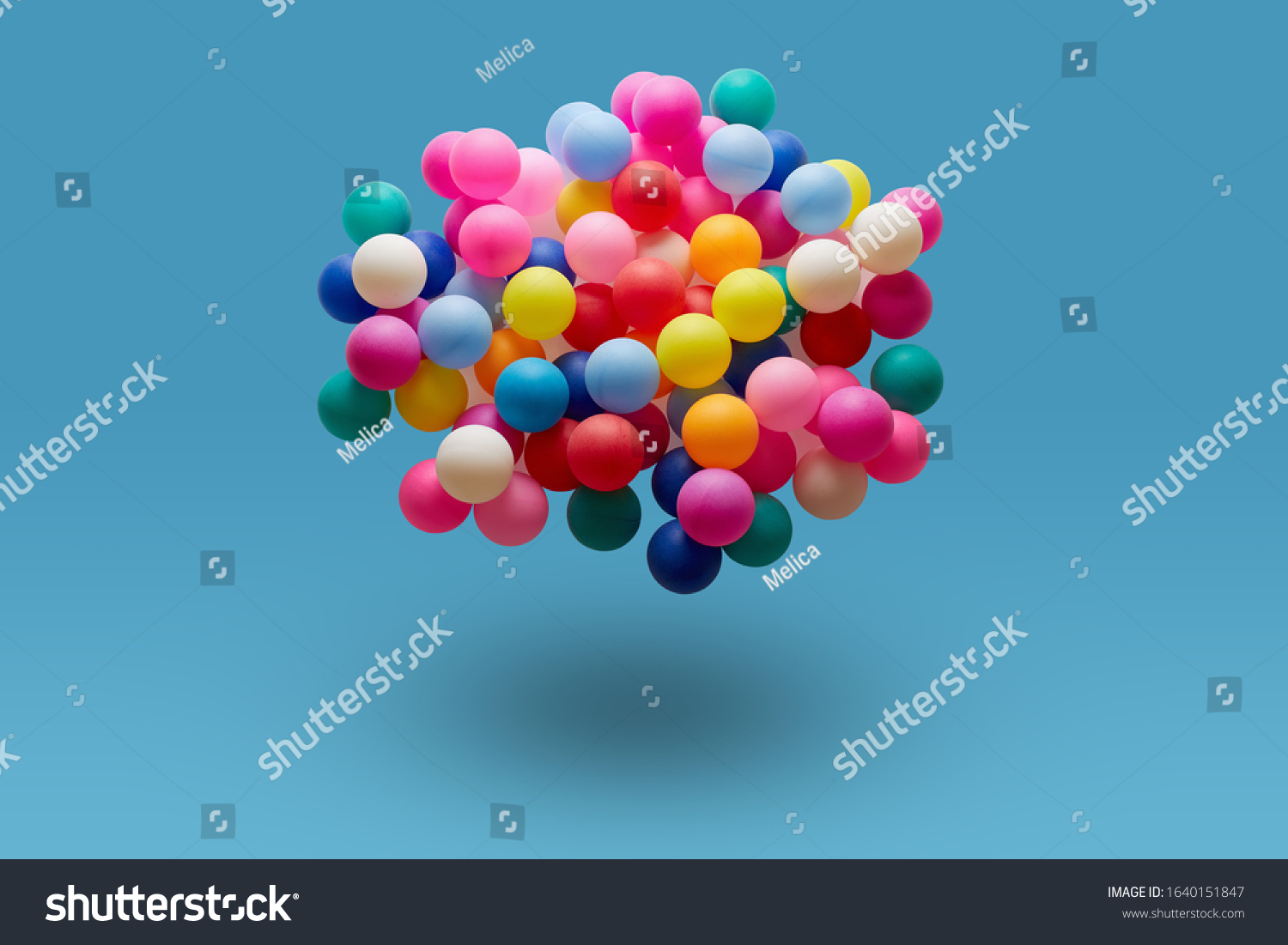 Multi colored balls levitation in mid air on blue background. 