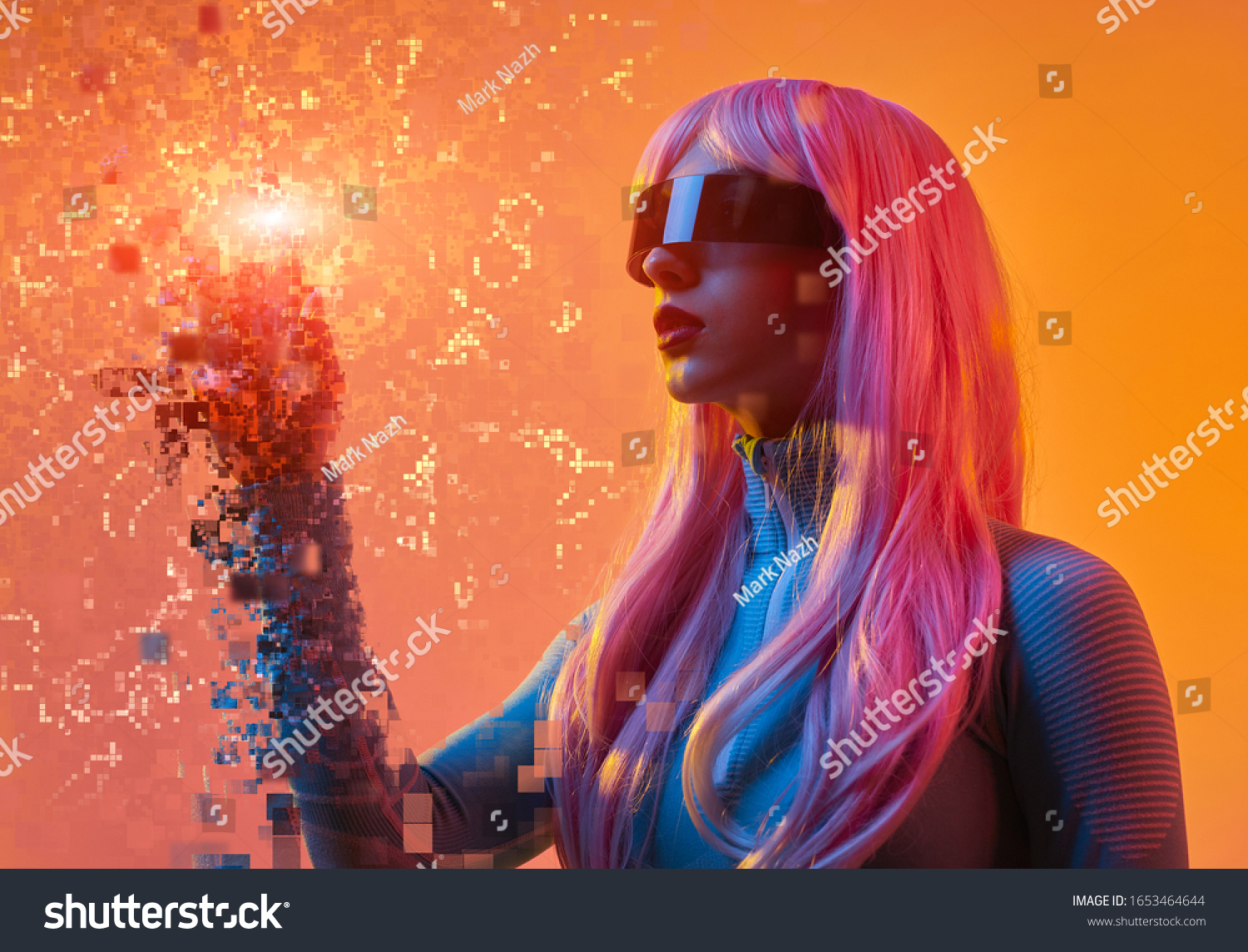 Young futuristic lady in VR glasses and pink wig touching pixels in virtual reality against orange background