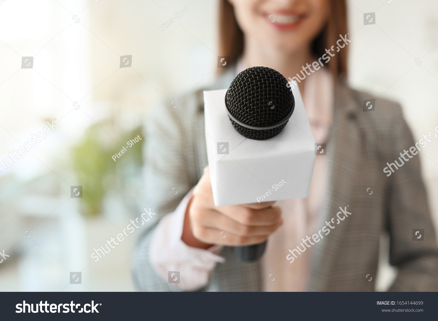 Female journalist with microphone in office  closeup