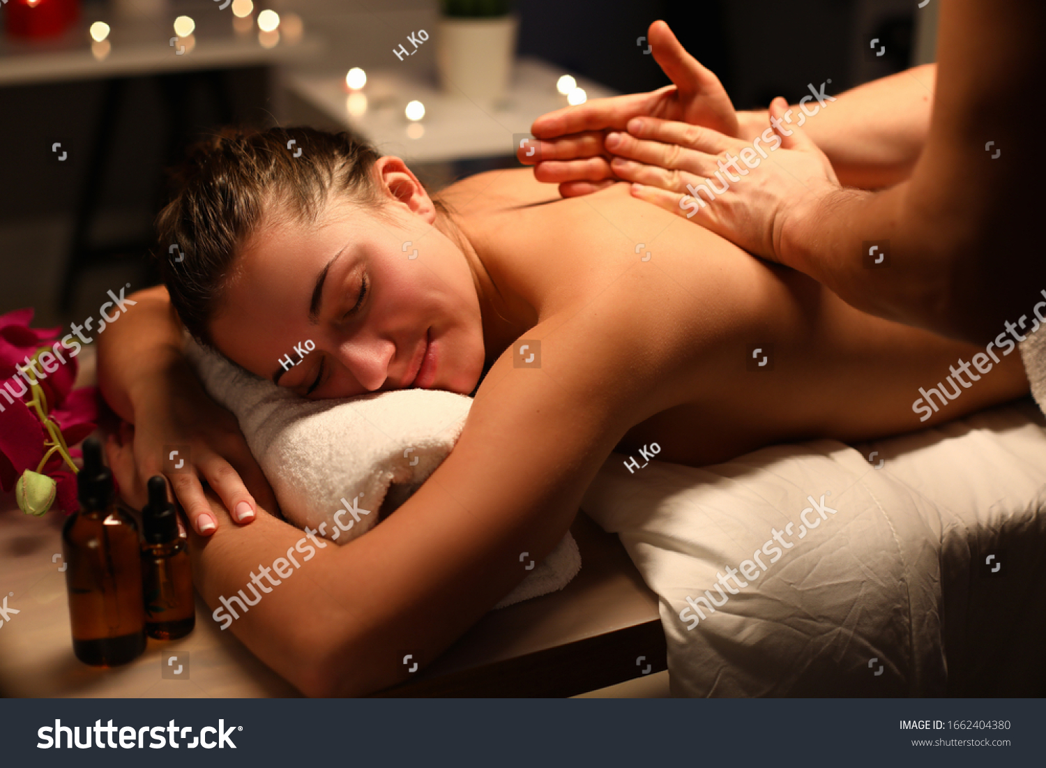 Young woman doing relaxing back massage in salon. Classic massage for purpose prevention. Anxiety disappears  tension is relieved. Lady in cozy atmosphere cabin to feel peace and quiet