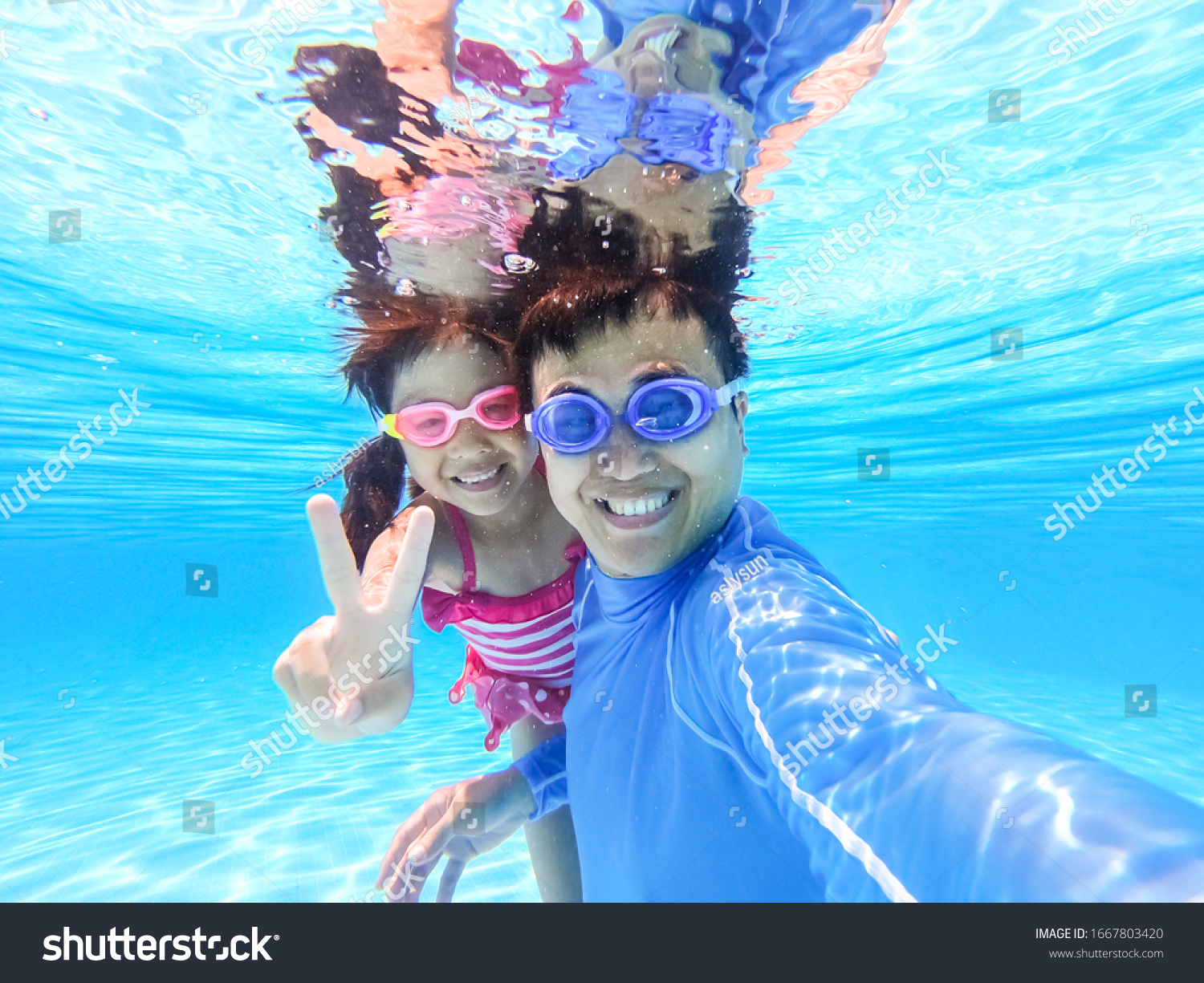 asian cute daughter and father play and selfie happily in the swimming pool