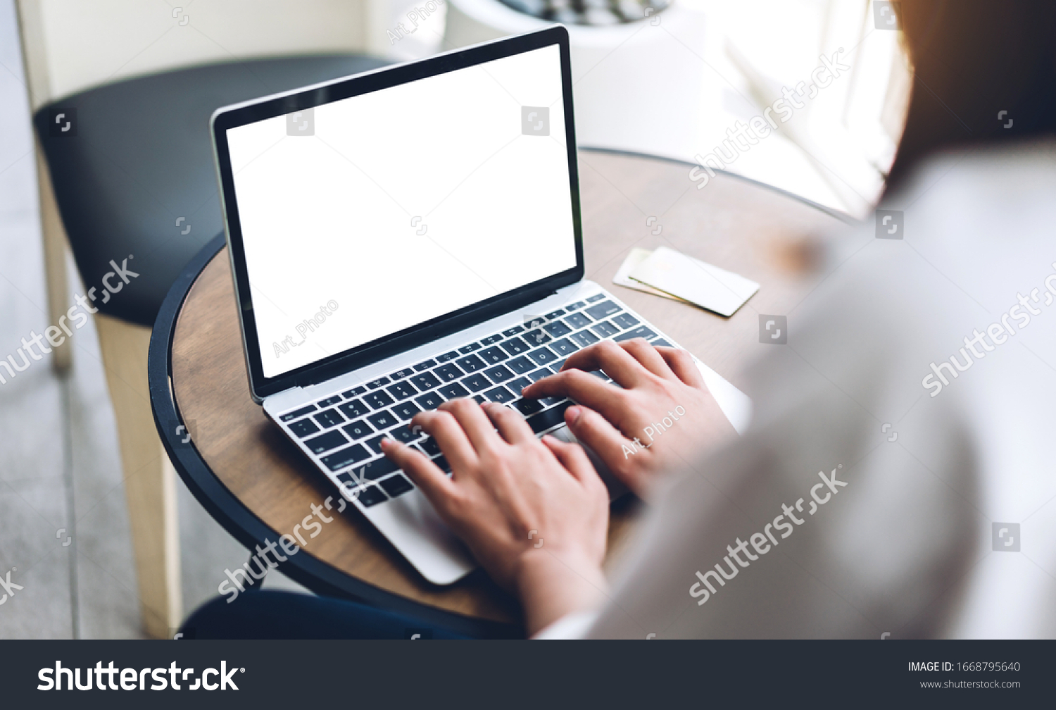 Woman relaxing using technology of laptop computer with white mockup blank screens while sitting on chair in cafe and restaurant.Communication and technology concept