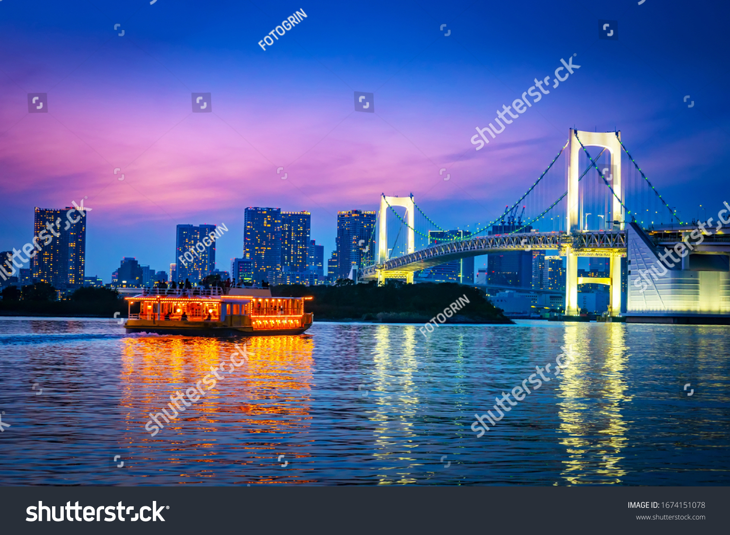 Japan. Tokyo. Odaiba island. The rainbow bridge glows at night. The ship floats on Tokyo Bay. Tours of Tokyo at night. Rainbow bridge on the background of the night city. Vacations in Japan.