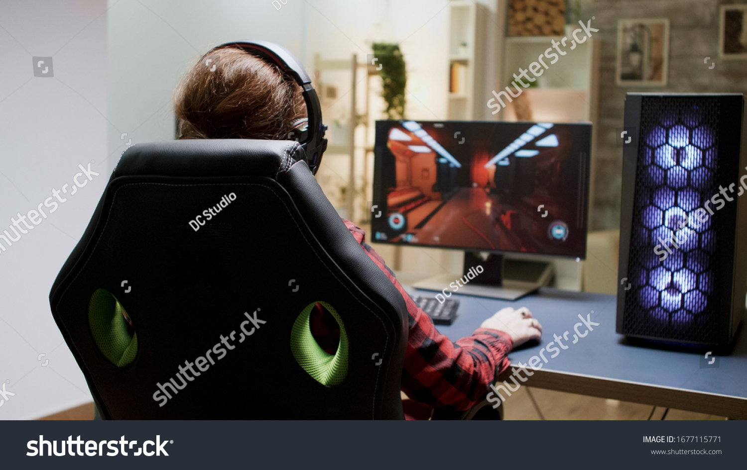 Back view of woman with red hair playing online shooter games sitting on gaming chair.