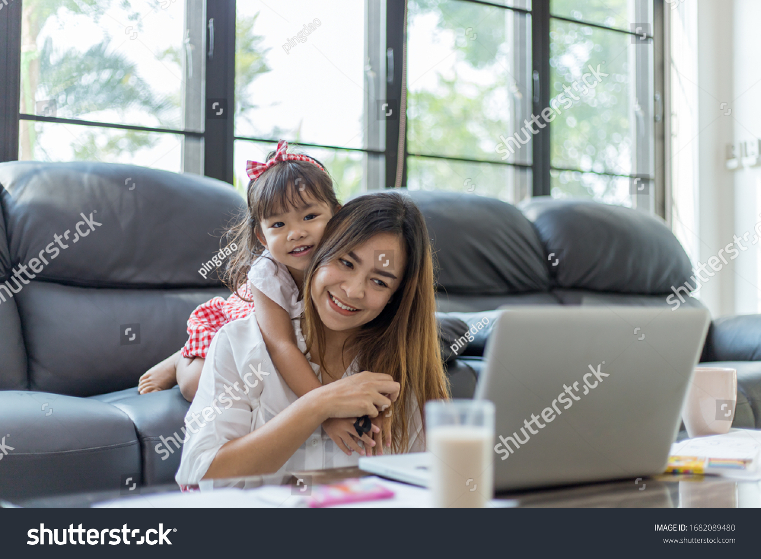 Family concept. Mom is working and taking care of her daughter too.