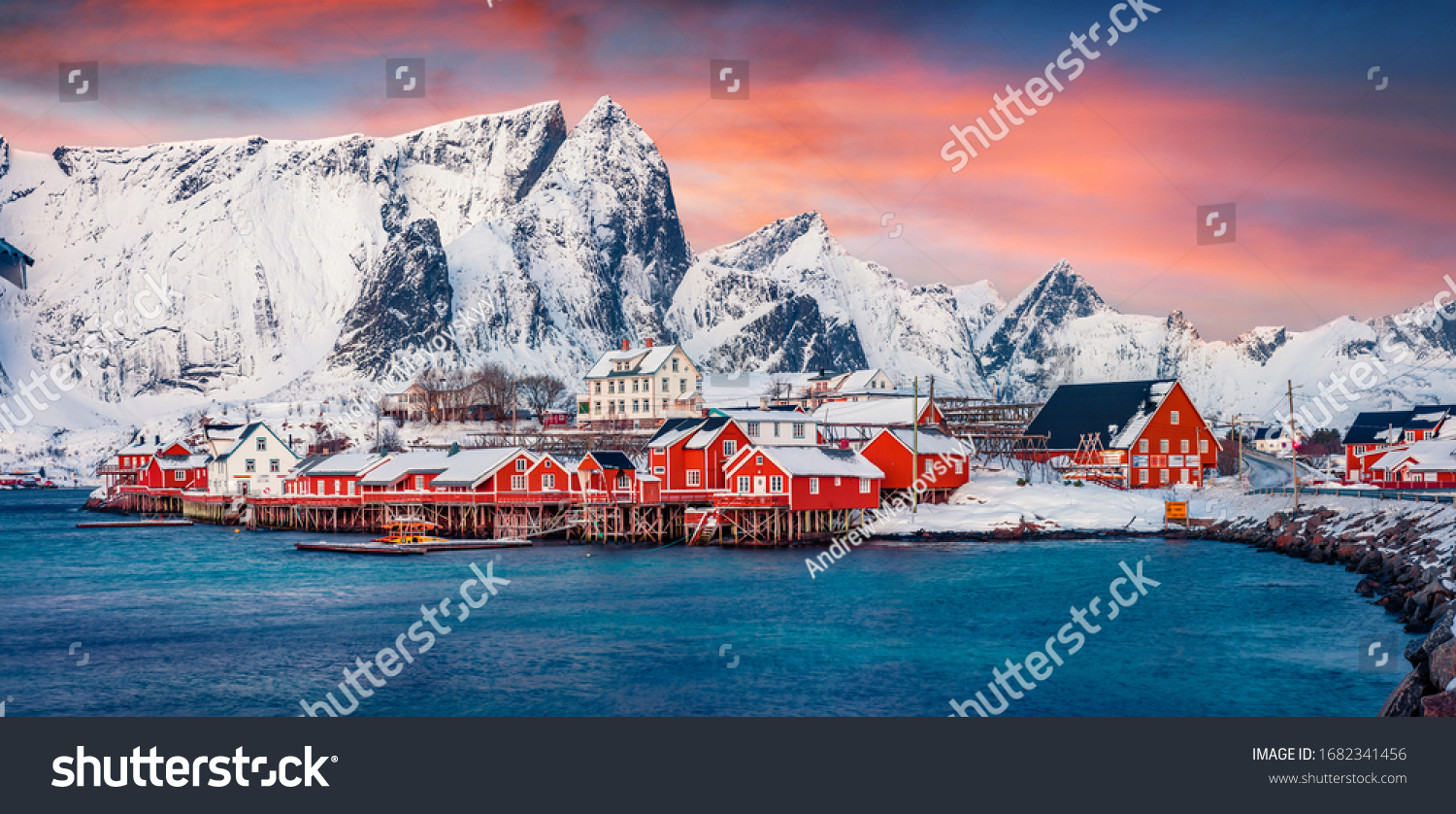 Panoramic evening view of popular tourist destination - Lofoten Islands archipelago. Colorful houses on the shore of Norwegian sea. Wonderful winter scene of Sakrisoy fishing village.