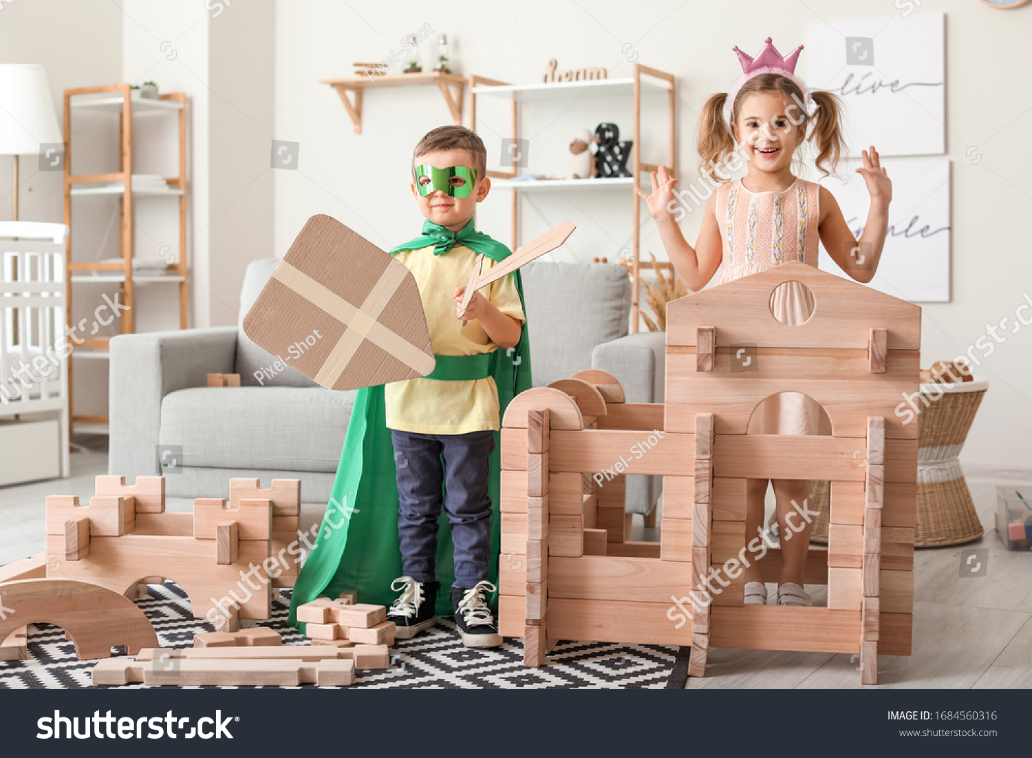 Little children in costumes playing with take-apart house at home