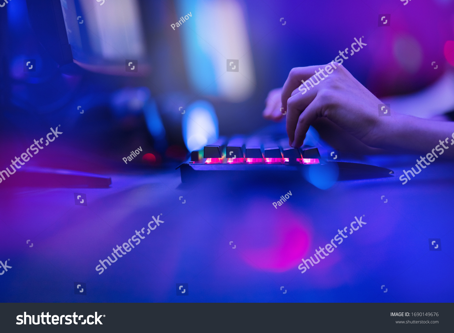 Hacker uses keyboard  shakes buttons with fingers to crack password. Internet security concept  cyber attack. Neon blue color.