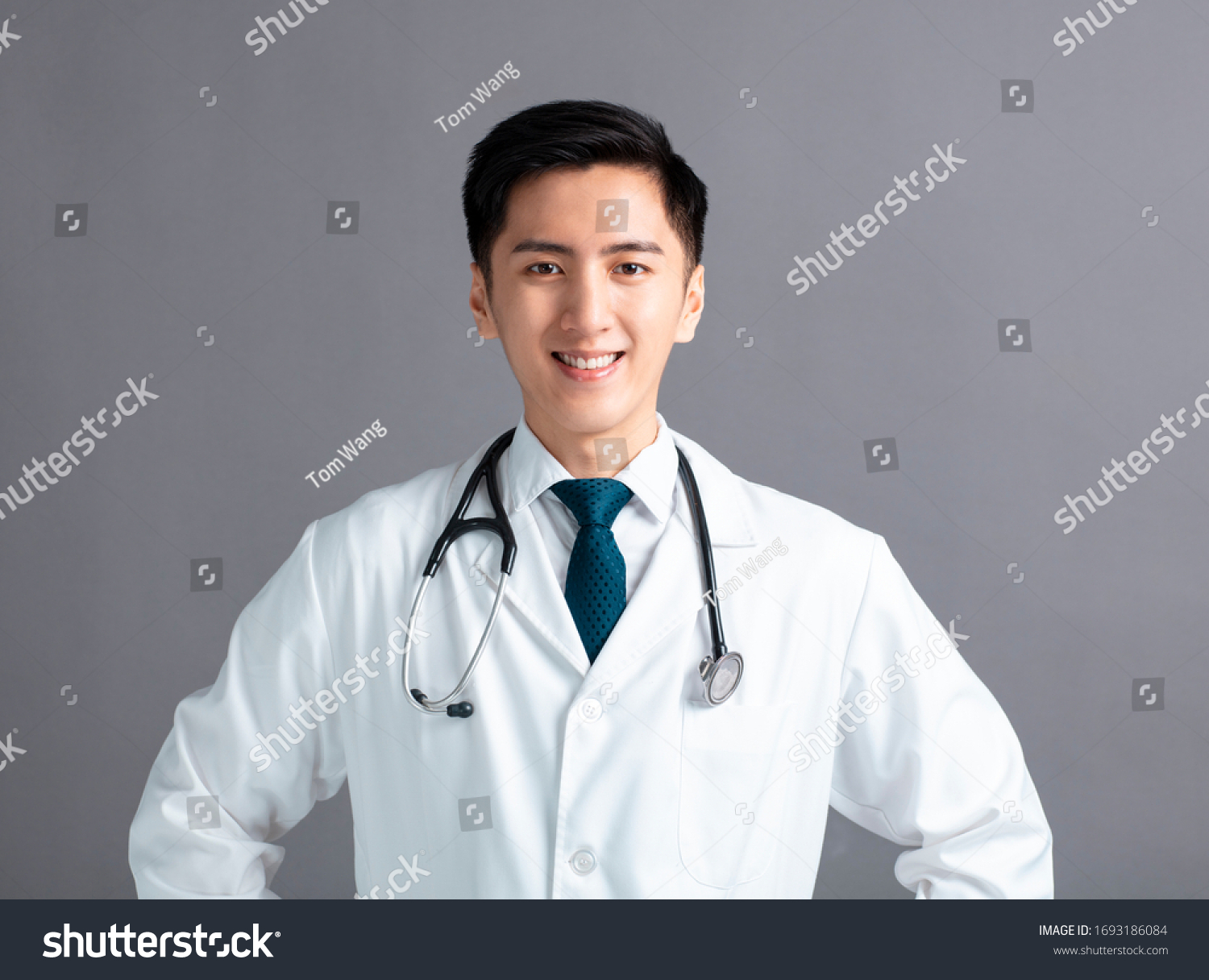 Portrait of male asian young doctor on gray  background