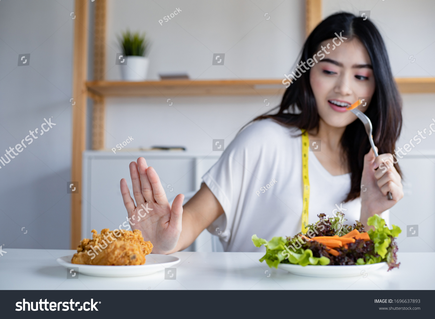 Woman choose to eat healthy vegetables and refuse to eat fried chicken. Woman on dieting for good health concept. Young woman rejecting junk food and choosing healthy food fresh vegetable.