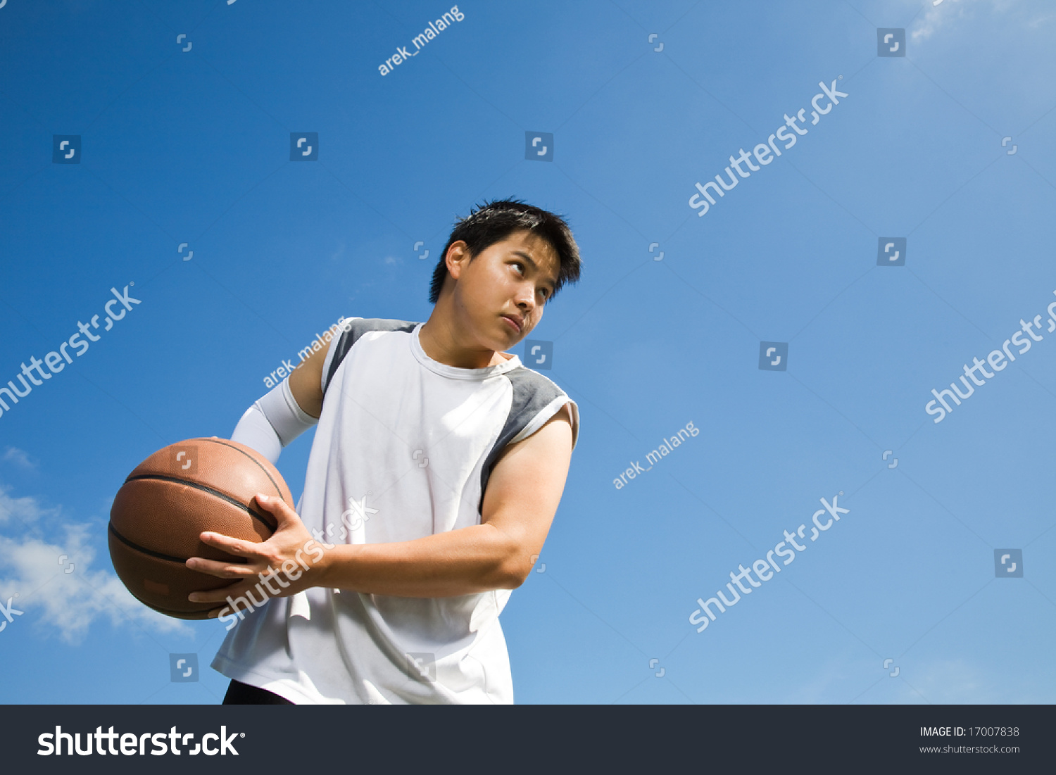 A shot of an asian basketball player holding a basketball