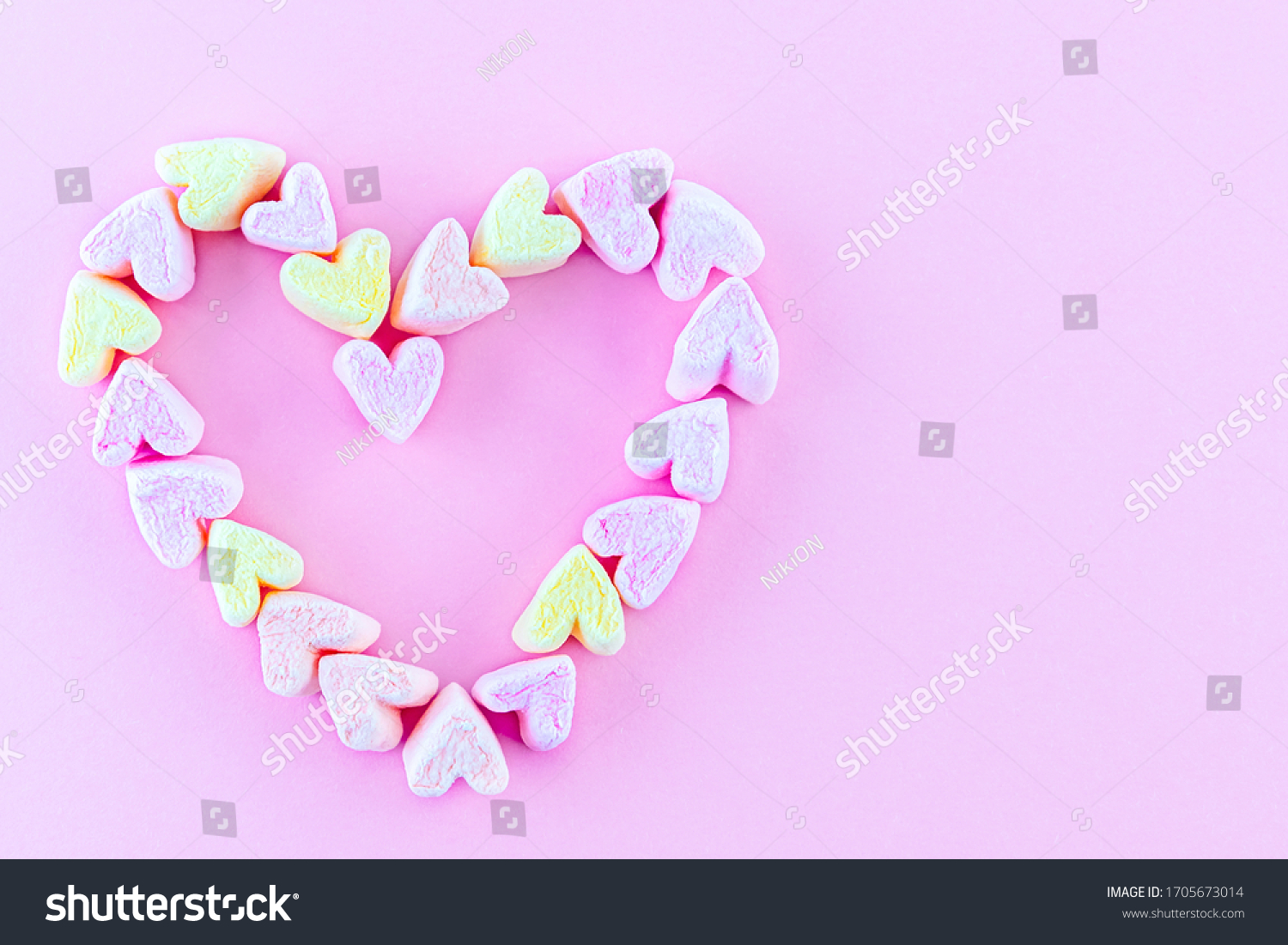 Heart shape made of bright marshmallows on a pink background. Abstract concept of love  Valentine's Day  confession of feelings. Copy space.