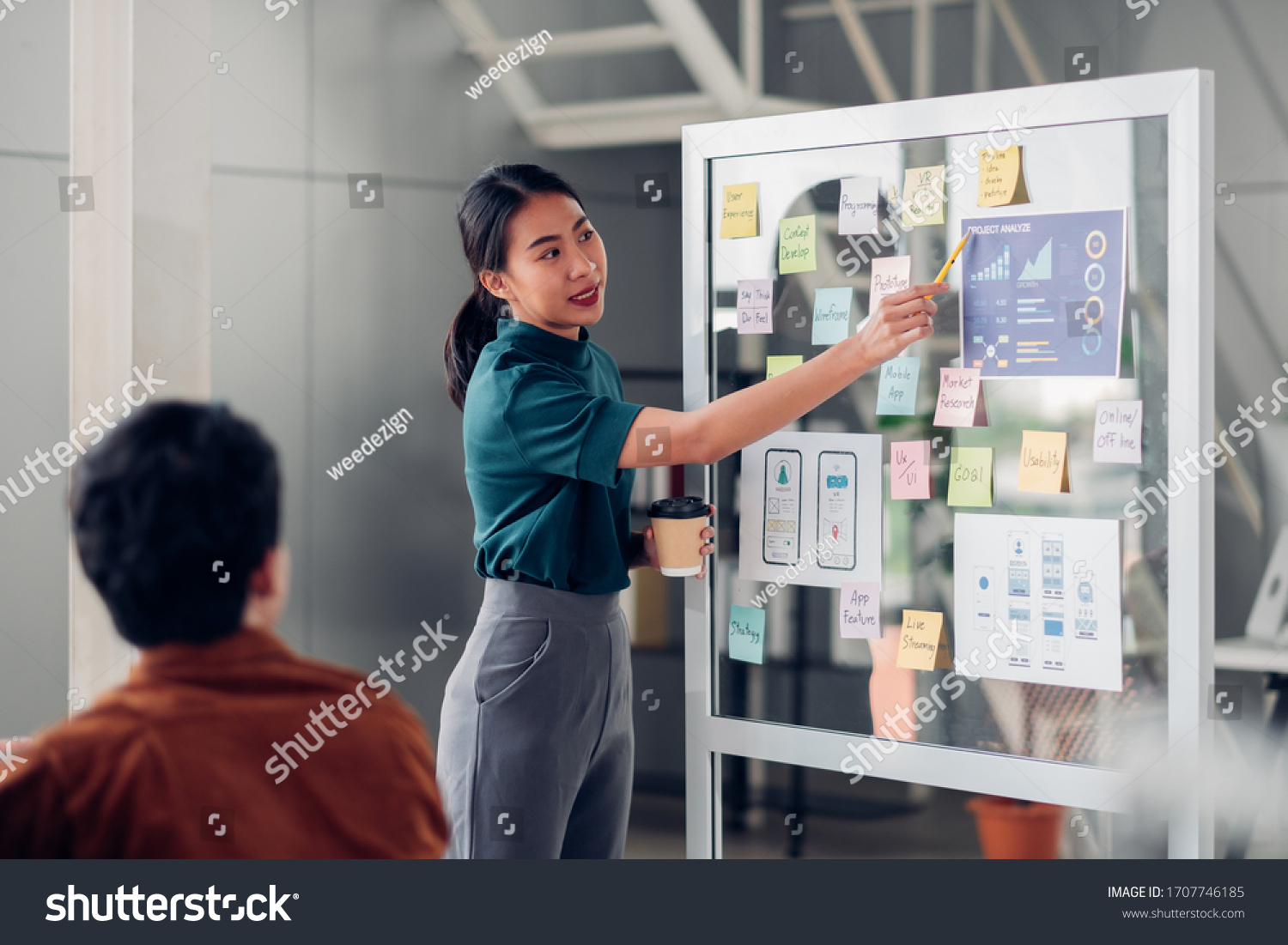 asian ux developer and ui designer presenting mobile app interface design on whiteboard in meeting at modern office.Creative digital development mobile app agency.digital transformation