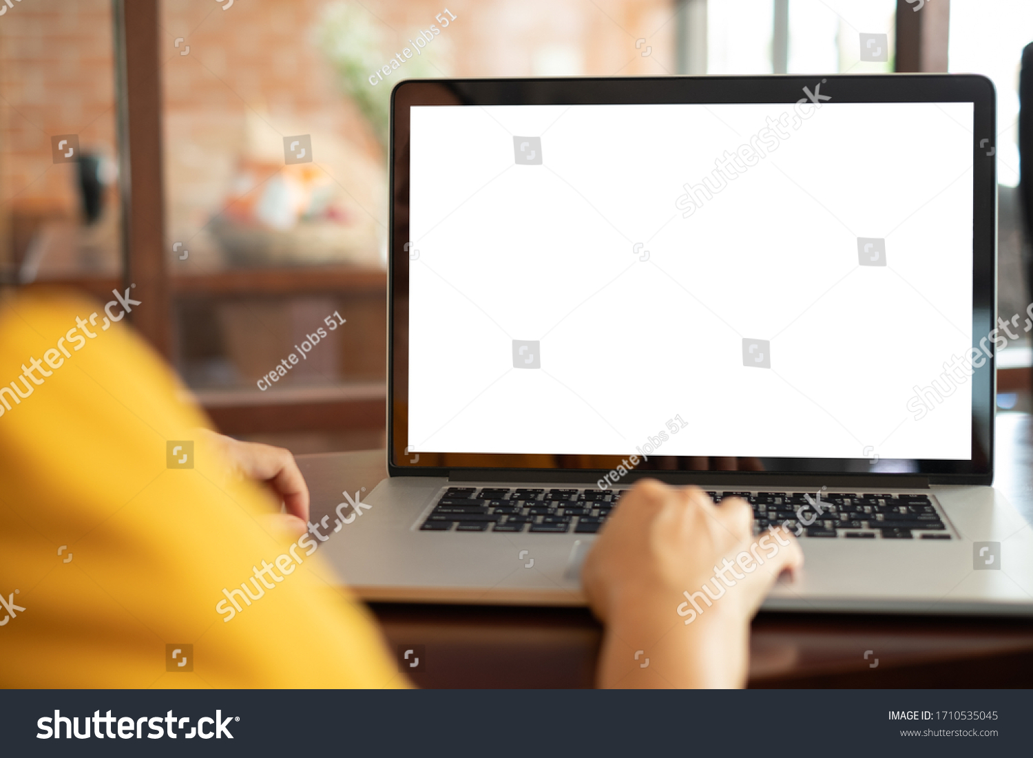 women using laptop computer working at home with blank white desktop screen.