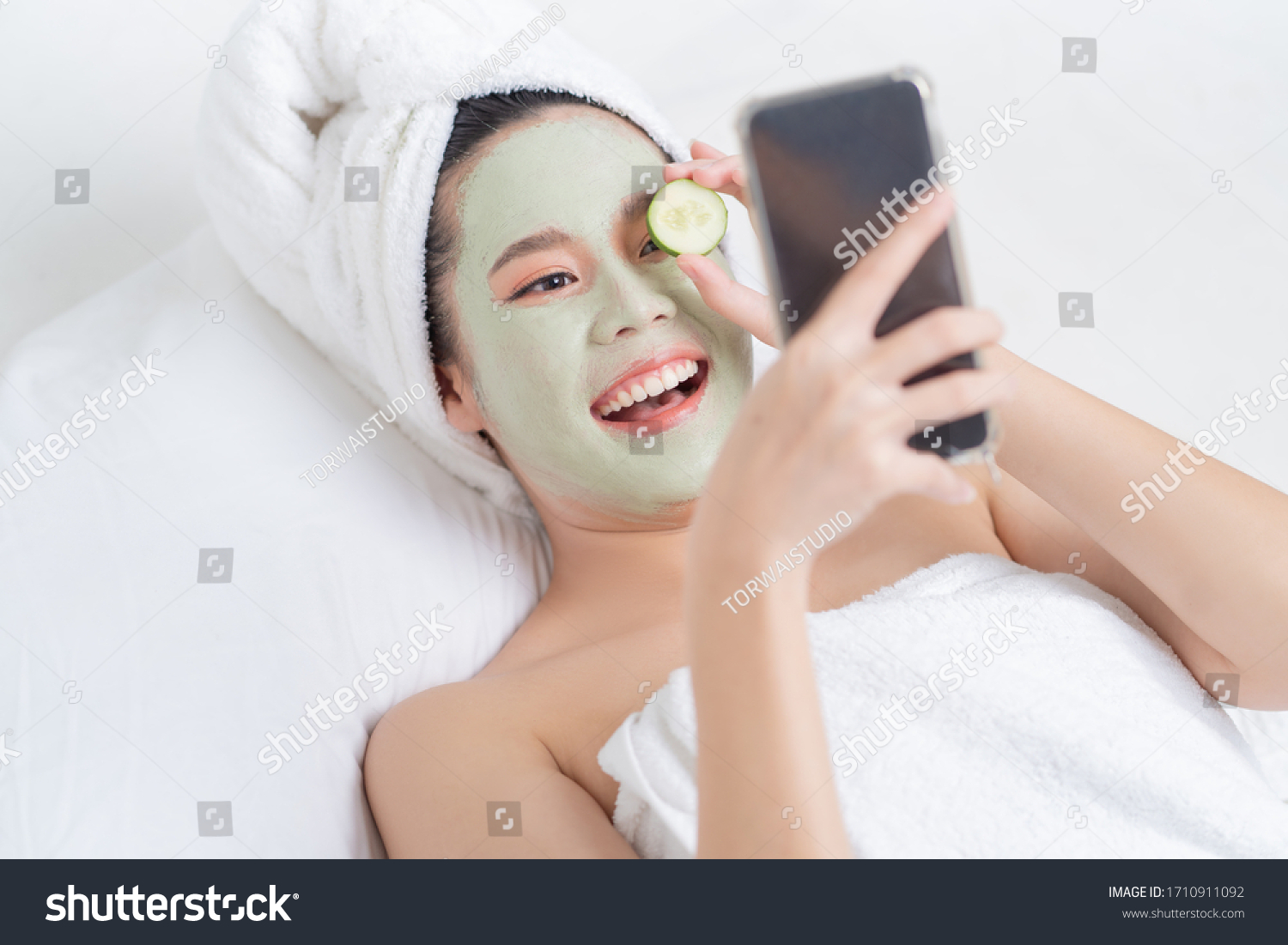 Asian woman is facial mask at home. She is live for her friends.