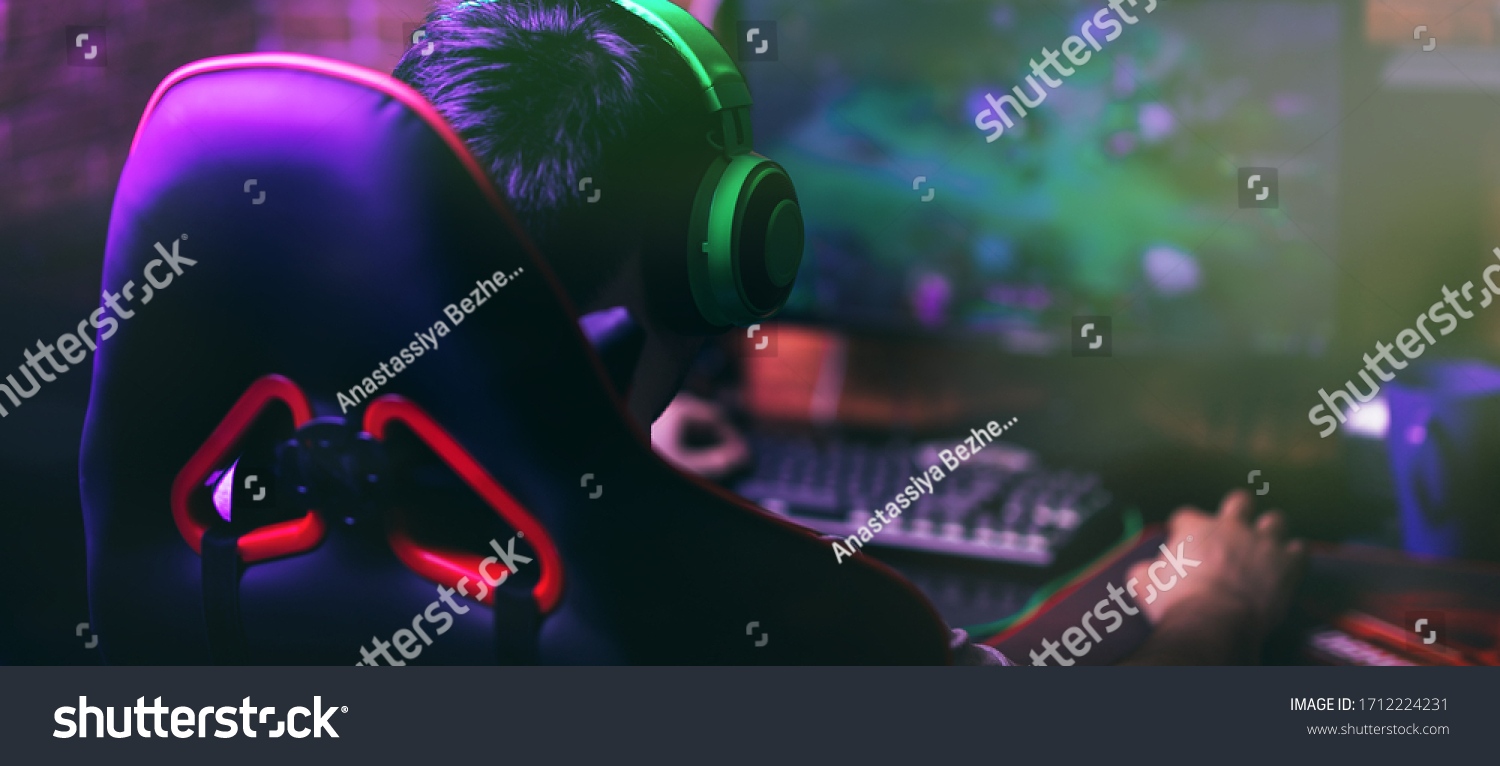 computer games  playing place  young gamer plays computer games with headphones 