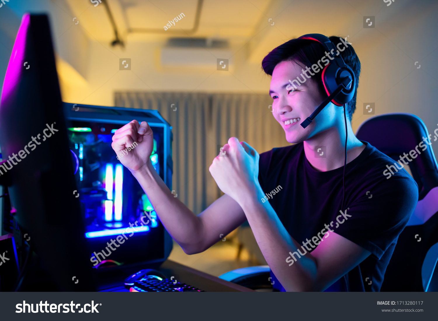 Young Asian Handsome Pro Gamer Feel Excited While playing in Online Cyber Sport Game at home