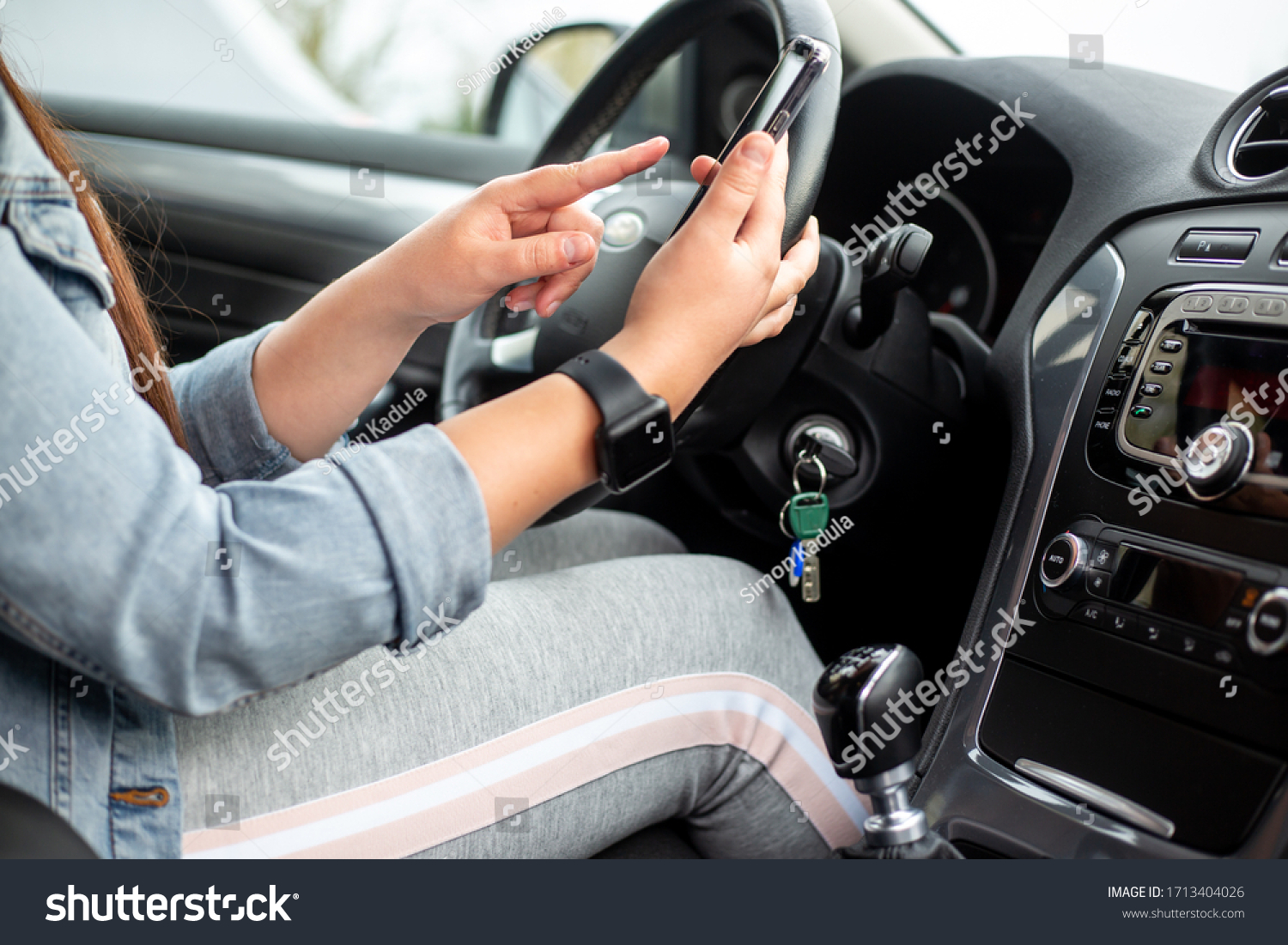 Woman driver using a mobile  smartphone during driving her car  dangerous concept