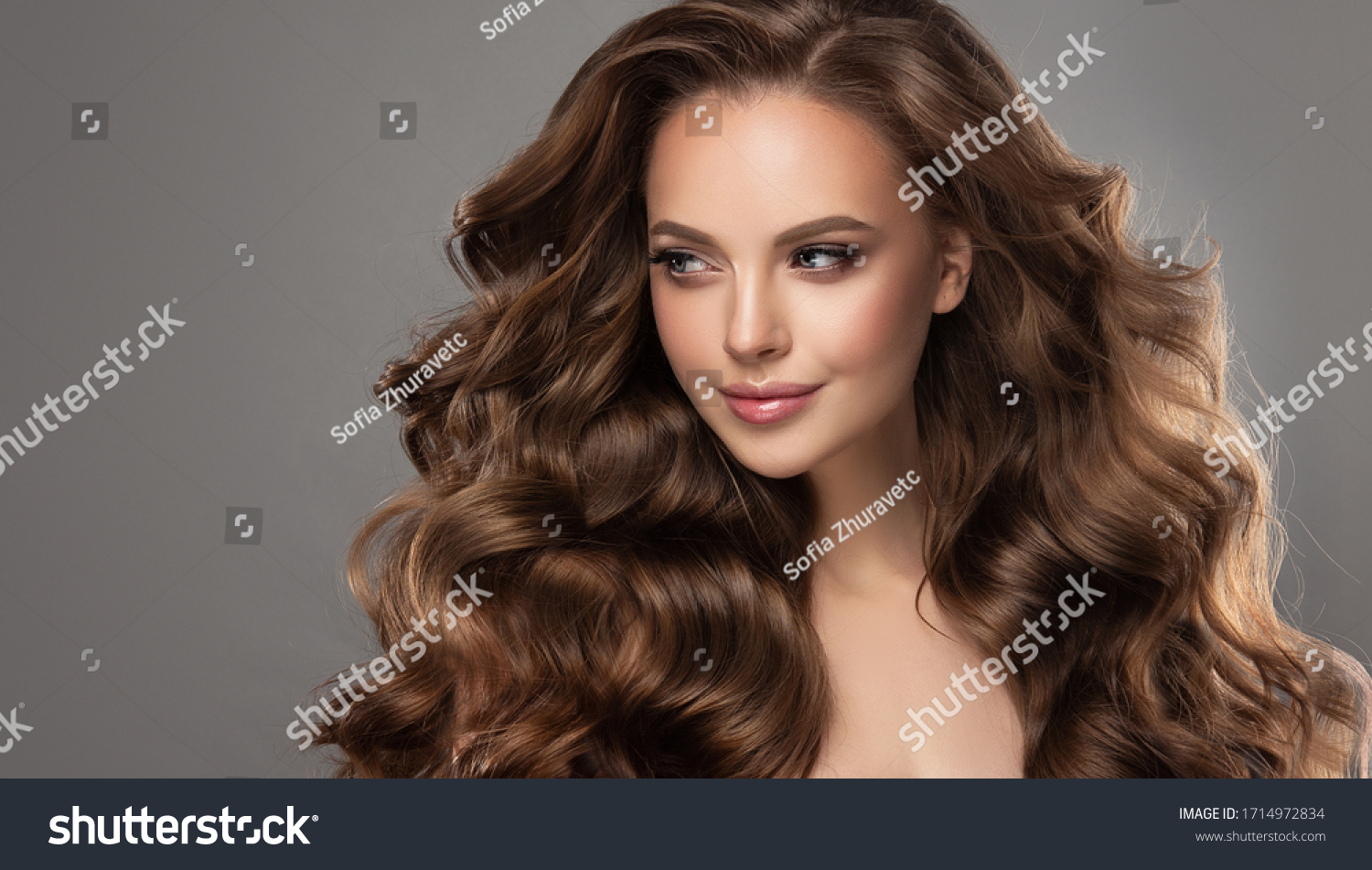 Beautiful model girl with long wavy and shiny hair . Brunette woman with curly hairstyle