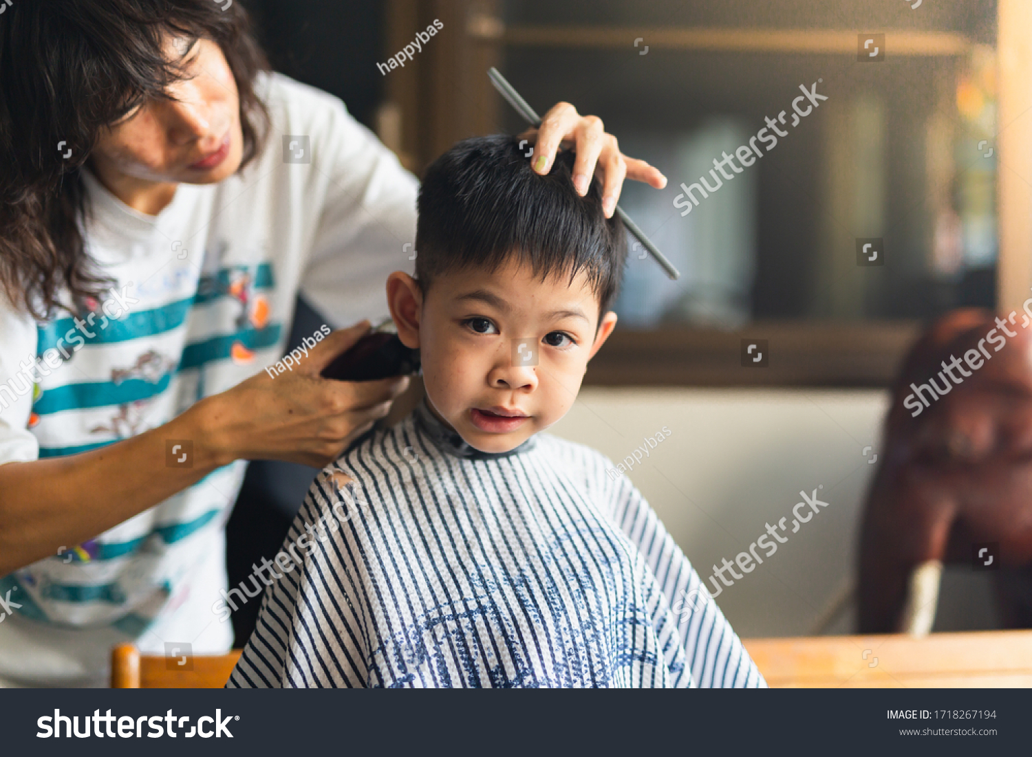 A barber is a person whose occupation is mainly to cut dress groom style and shave men’s and boys' hair. A barber's place of work is known as a barbershop.but this boy has new hair cut at home