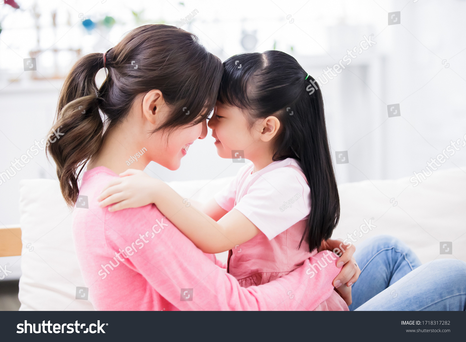 Mom hold daughter in her arm and child smile happily