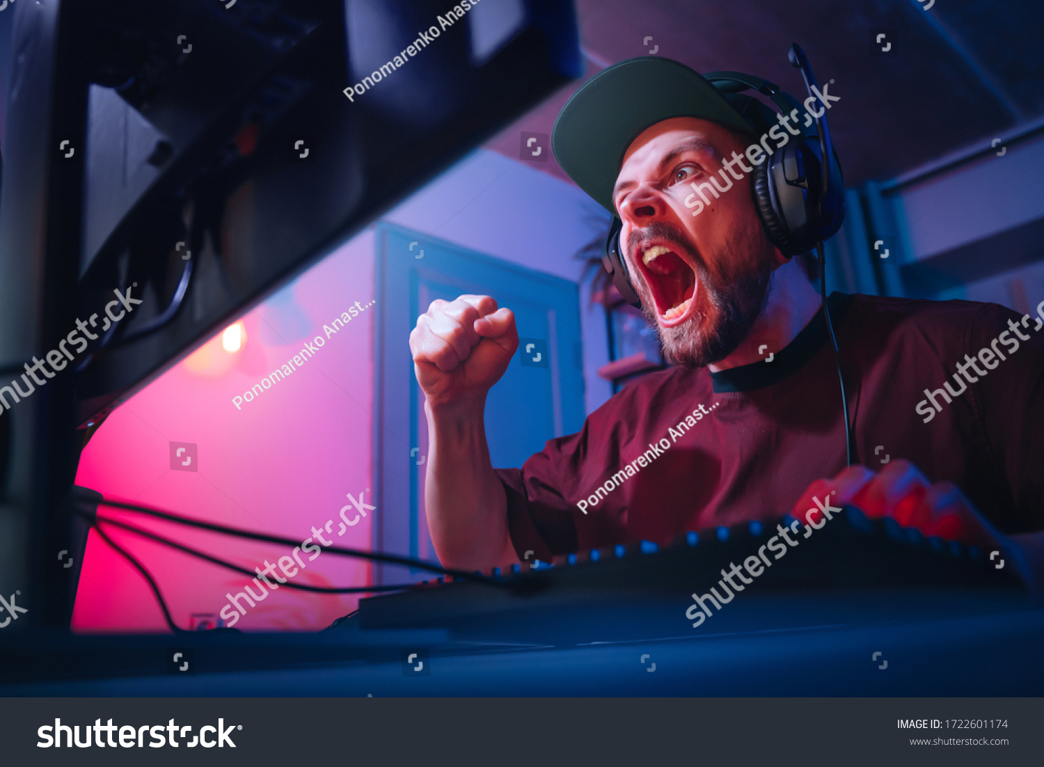 A man plays computer games at home. The guy is watching a video with headphones. The emotional player screams. Weekend at the screen. The irritated man lost.