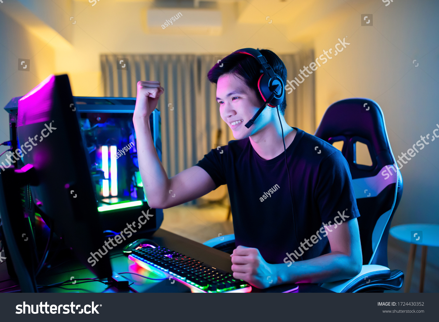 Young Asian Handsome Pro Gamer Feel Excited While playing in Online Cyber Sport Game at home