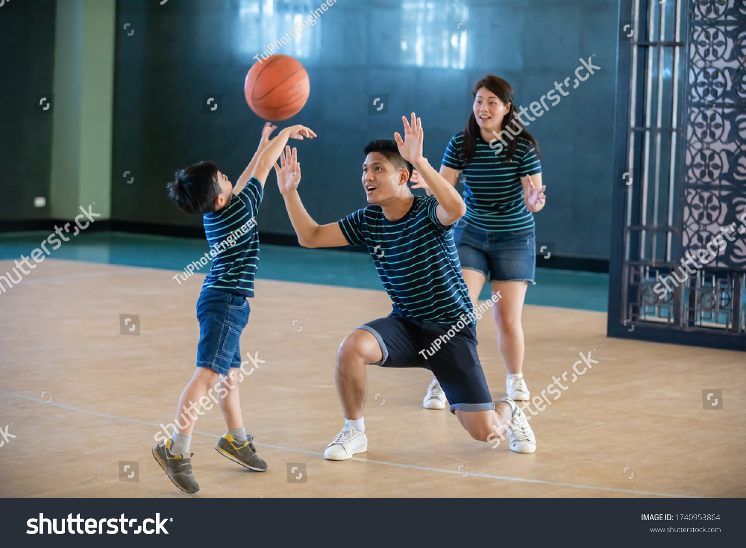 Asian family playing basketball together. Happy family spending free time together on holiday